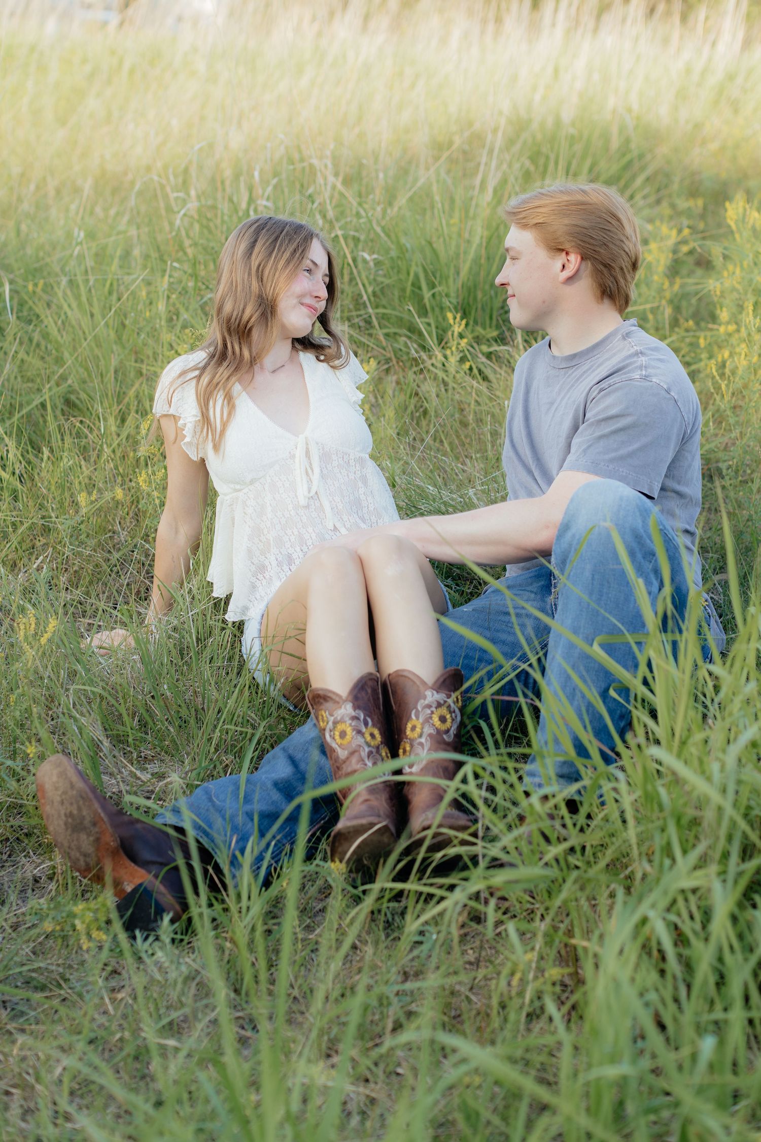 Romantic photo of a couple embracing on a hilltop at Prairie Bluffs, surrounded by open fields and wide Minnesota skies.