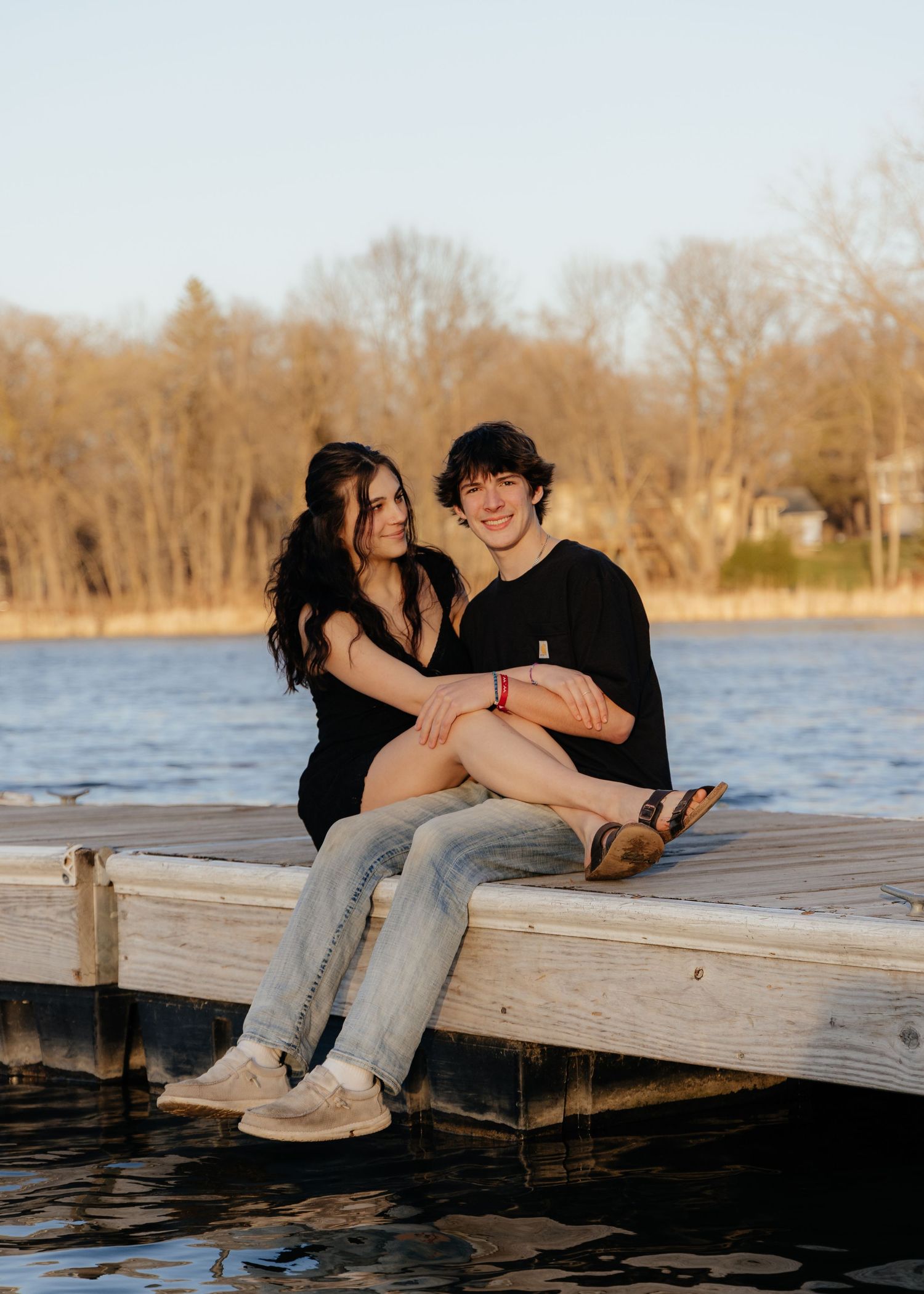 Couple laughing enjoying the blooming trees at Fish Lake Regional Park in Maple Grove, MN, with fresh green grass and soft spring sunlight