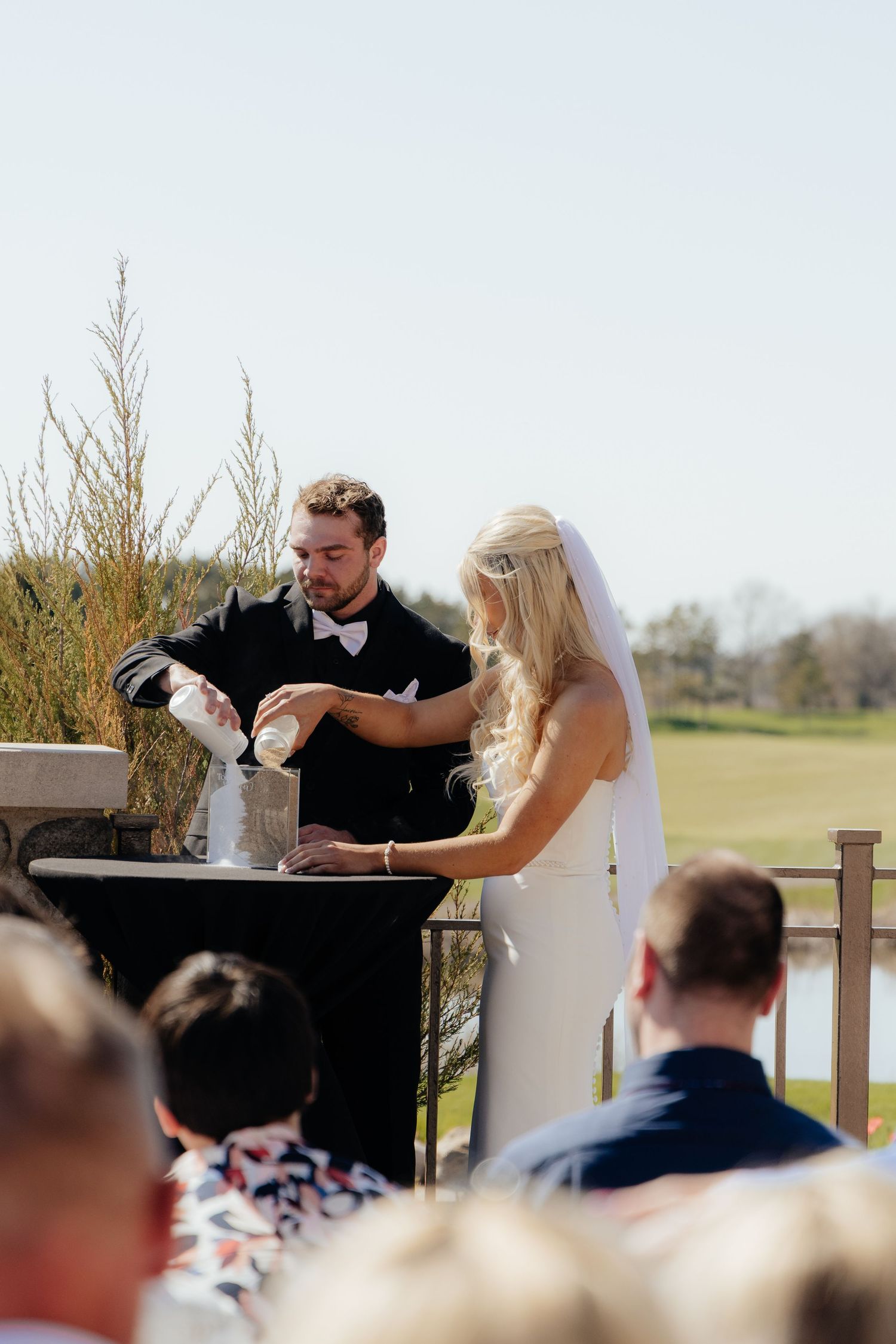 Bride and groom sharing a romantic moment at Rush Creek Golf Course in Maple Grove, MN, with rolling fairways and elegant floral decor