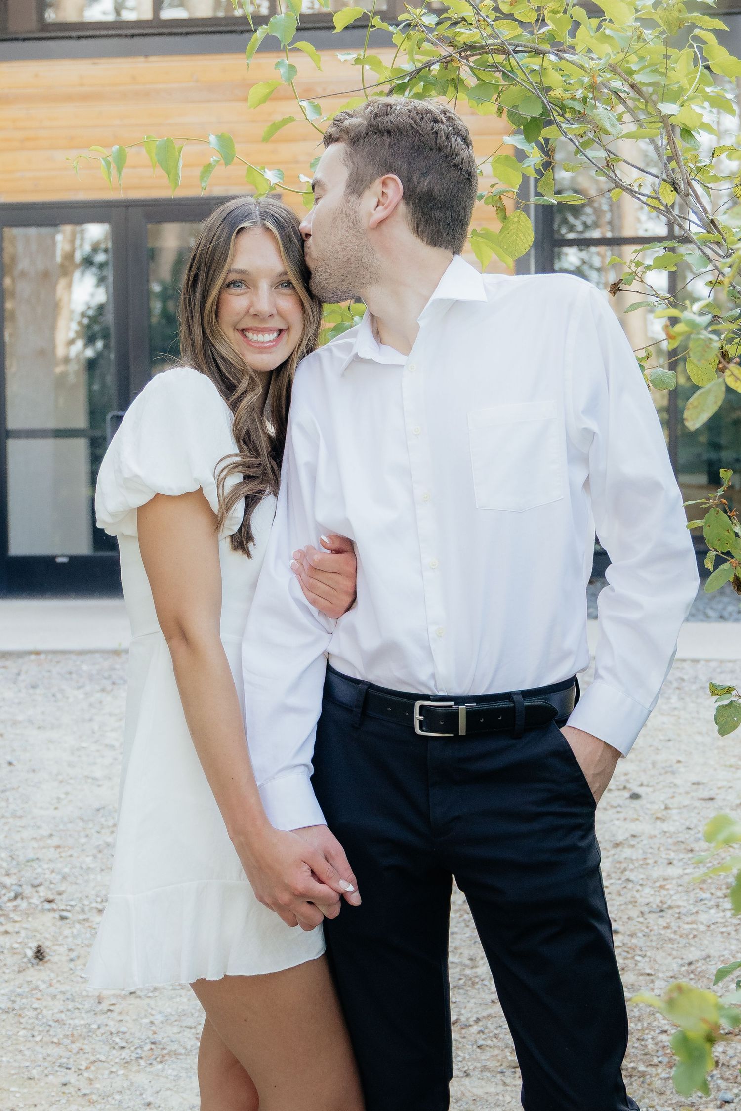Moody and romantic couples photo with the Pinewood venue softly blurred in the background, highlighting emotion and connection.