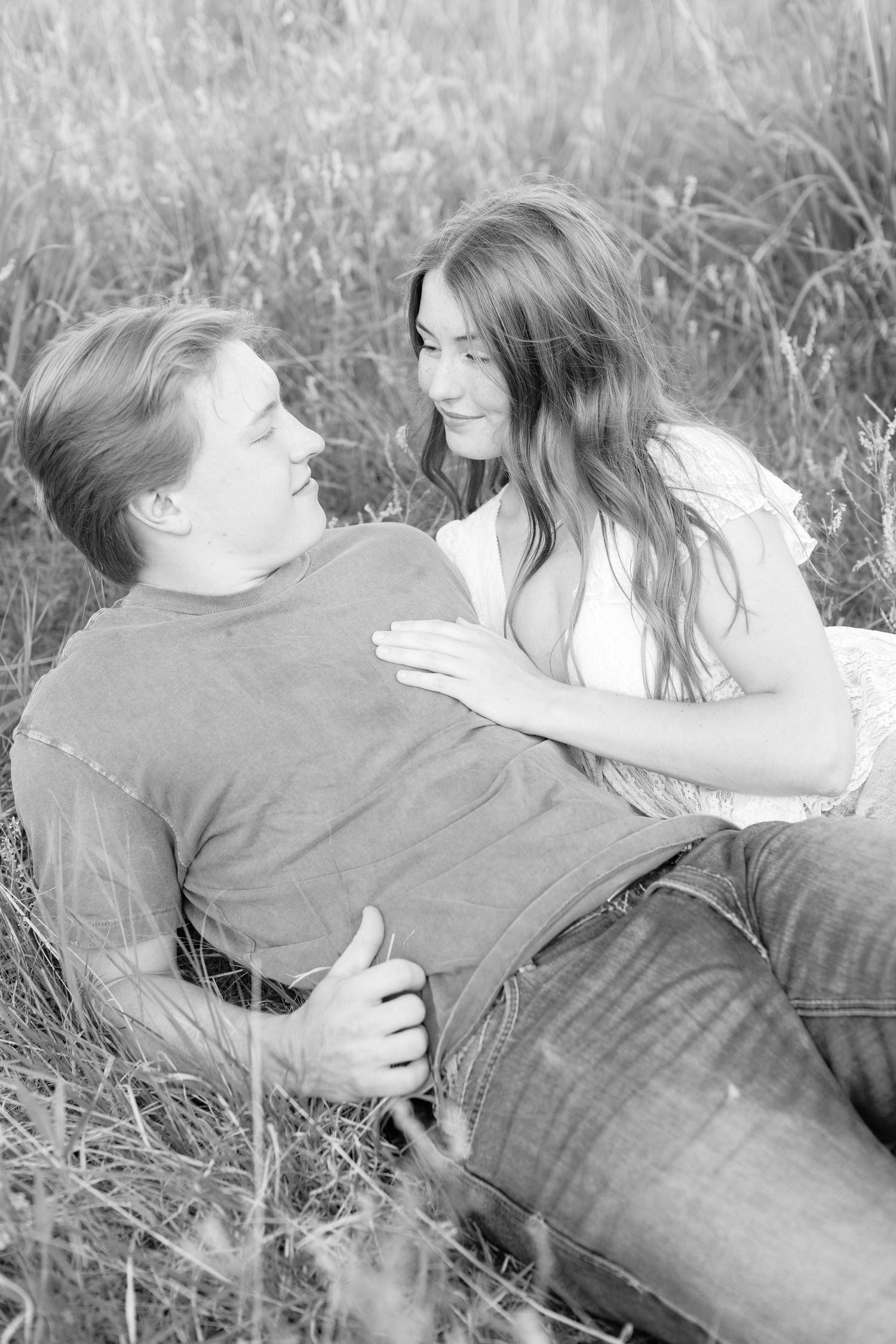 Romantic photo of a couple embracing on a hilltop at Prairie Bluffs, surrounded by open fields and wide Minnesota skies.