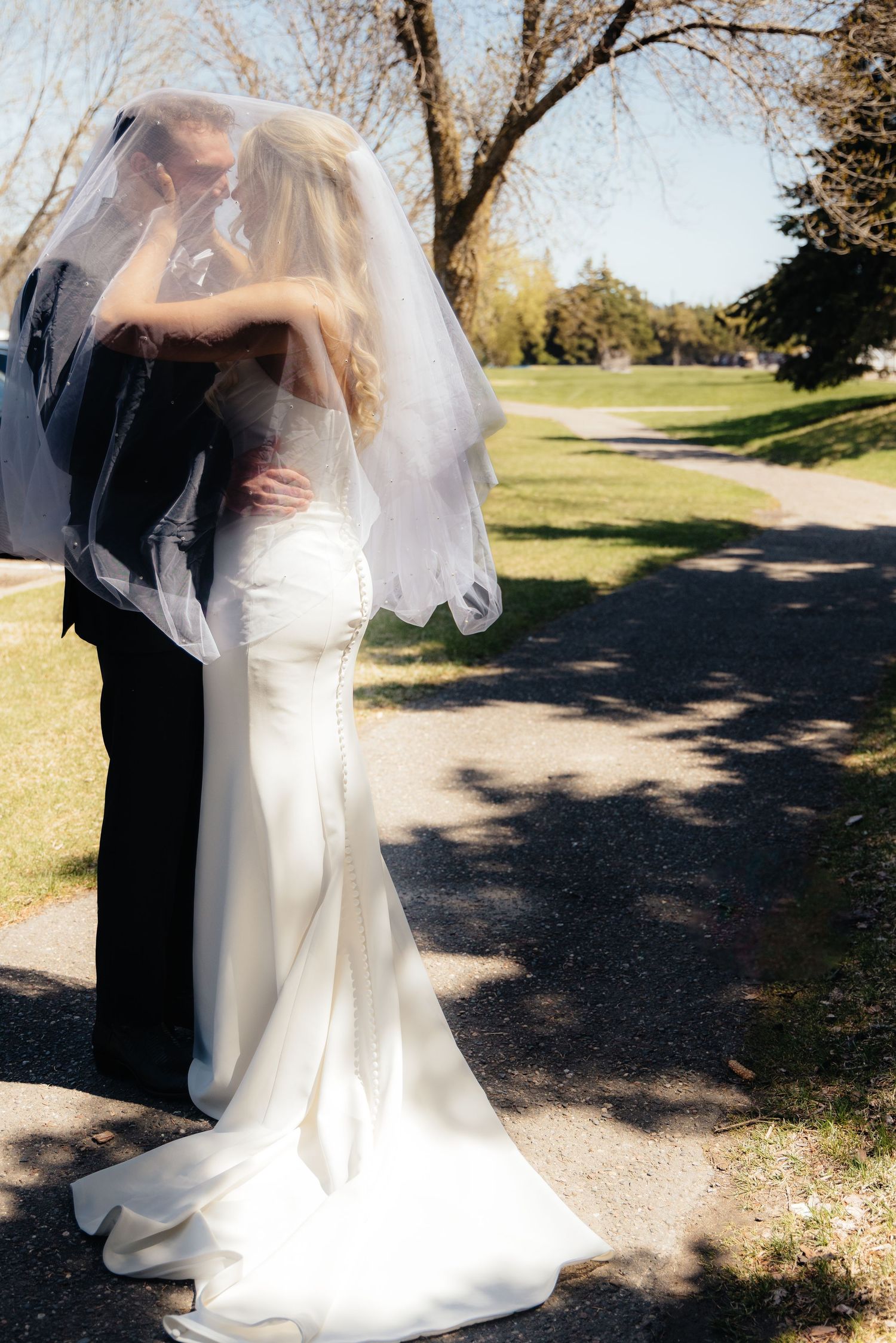 Bride and groom sharing a romantic moment at Rush Creek Golf Course in Maple Grove, MN, with rolling fairways and elegant floral decor