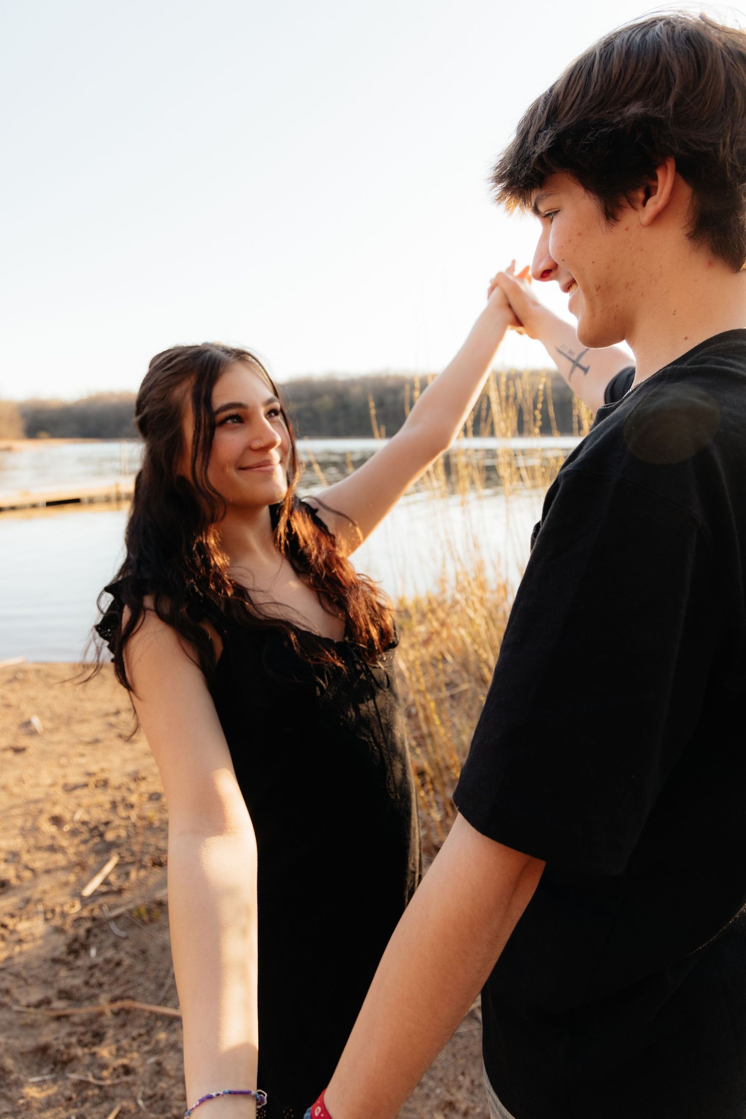 Couple laughing enjoying the blooming trees at Fish Lake Regional Park in Maple Grove, MN, with fresh green grass and soft spring sunlight