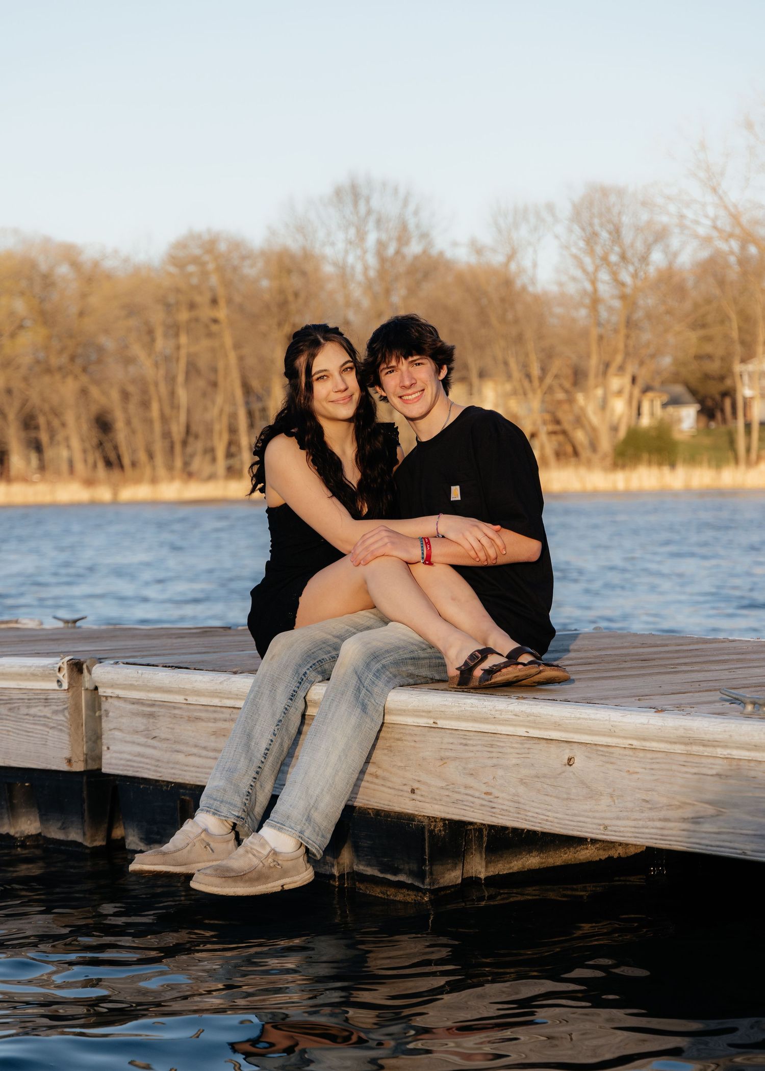 Couple laughing enjoying the blooming trees at Fish Lake Regional Park in Maple Grove, MN, with fresh green grass and soft spring sunlight