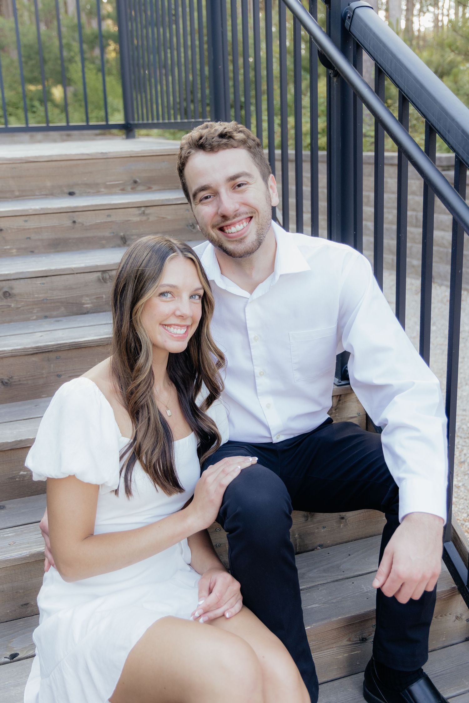 Golden-hour portrait of a couple embracing among tall trees at Pinewood in Cambridge, showcasing woodsy elegance.