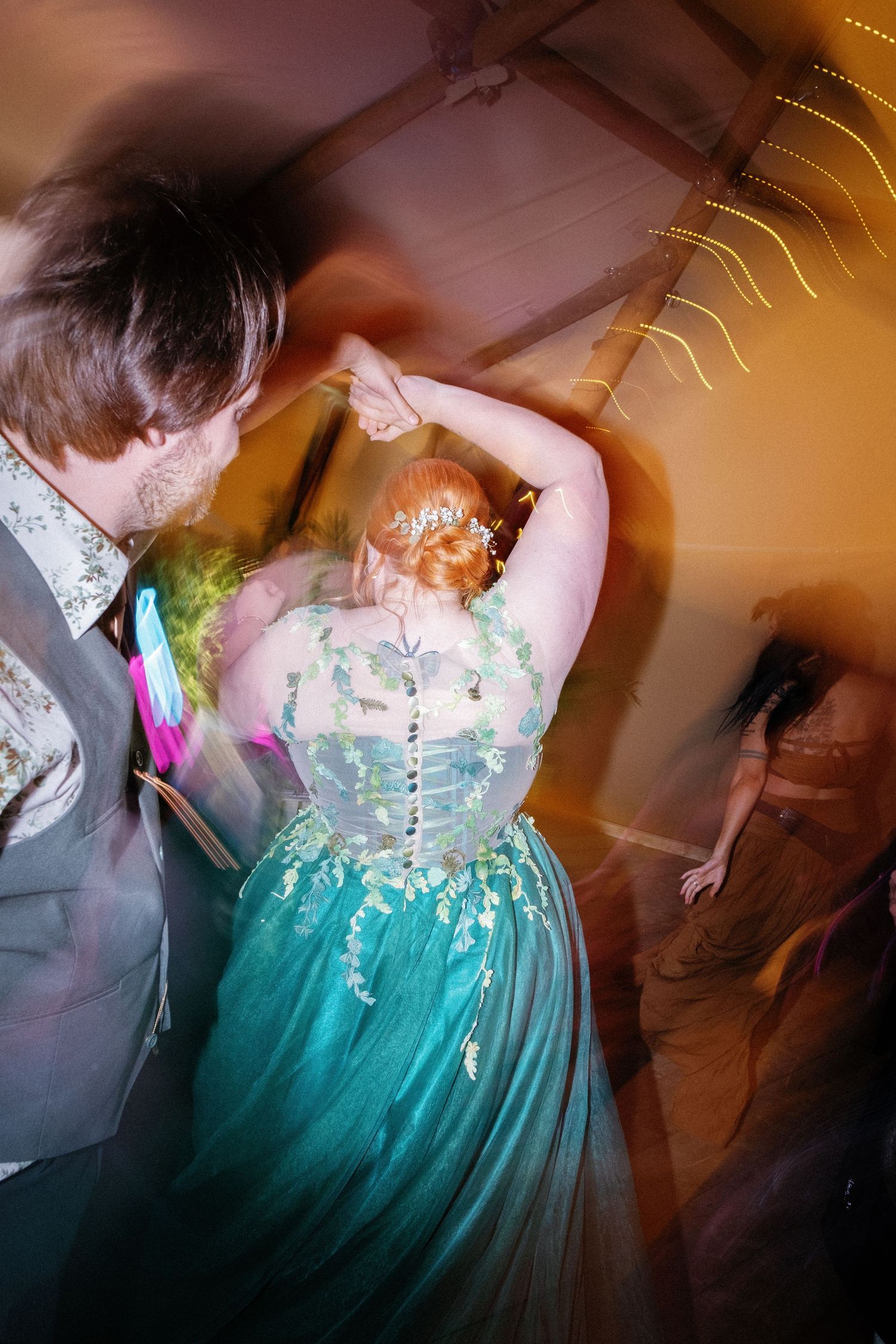 Close-up details of an emerald green ballgown with delicate lace bodice and flowing tulle skirt.