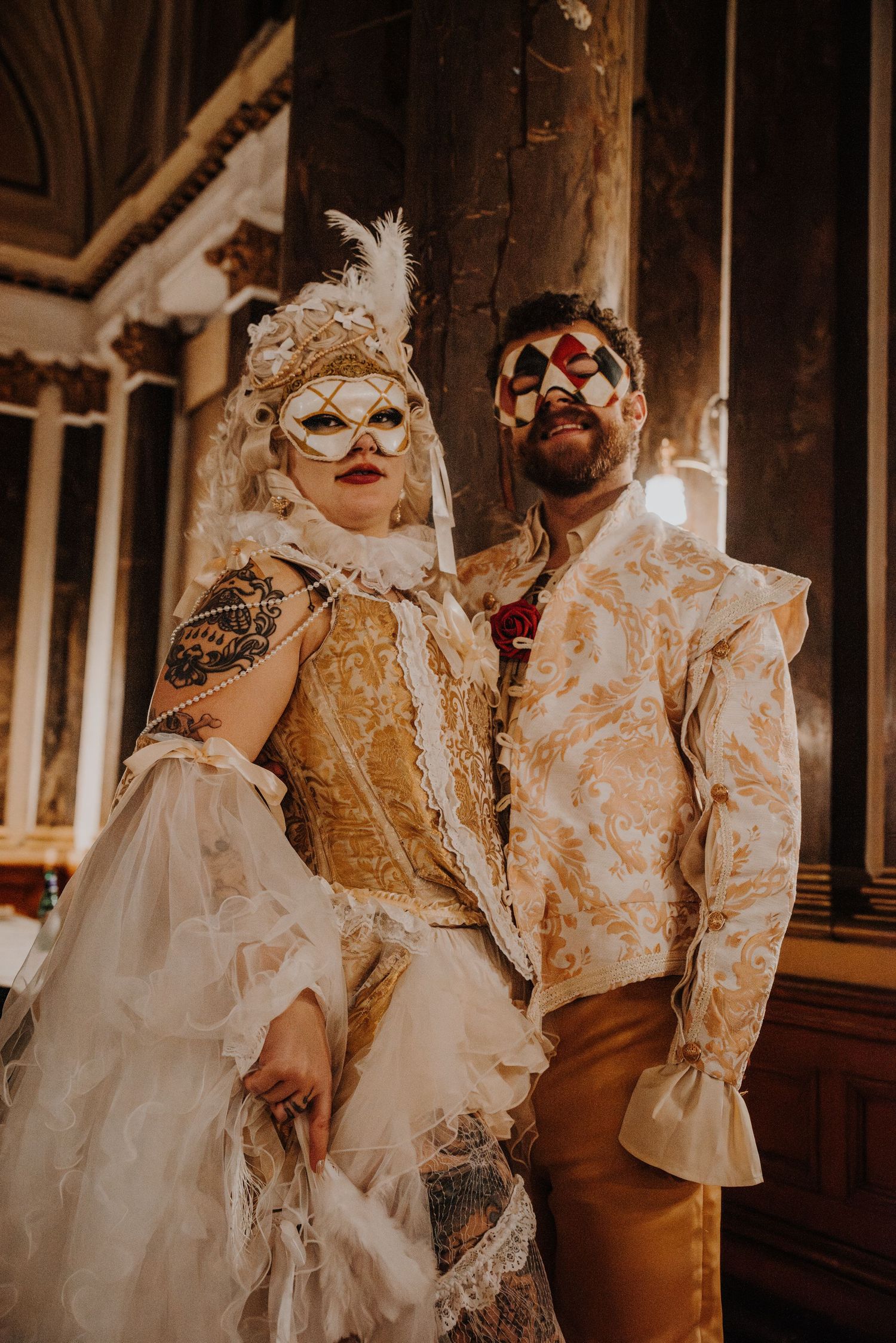 Group wearing elaborate Victorian-style costumes and masks pose at a fantasy ball.