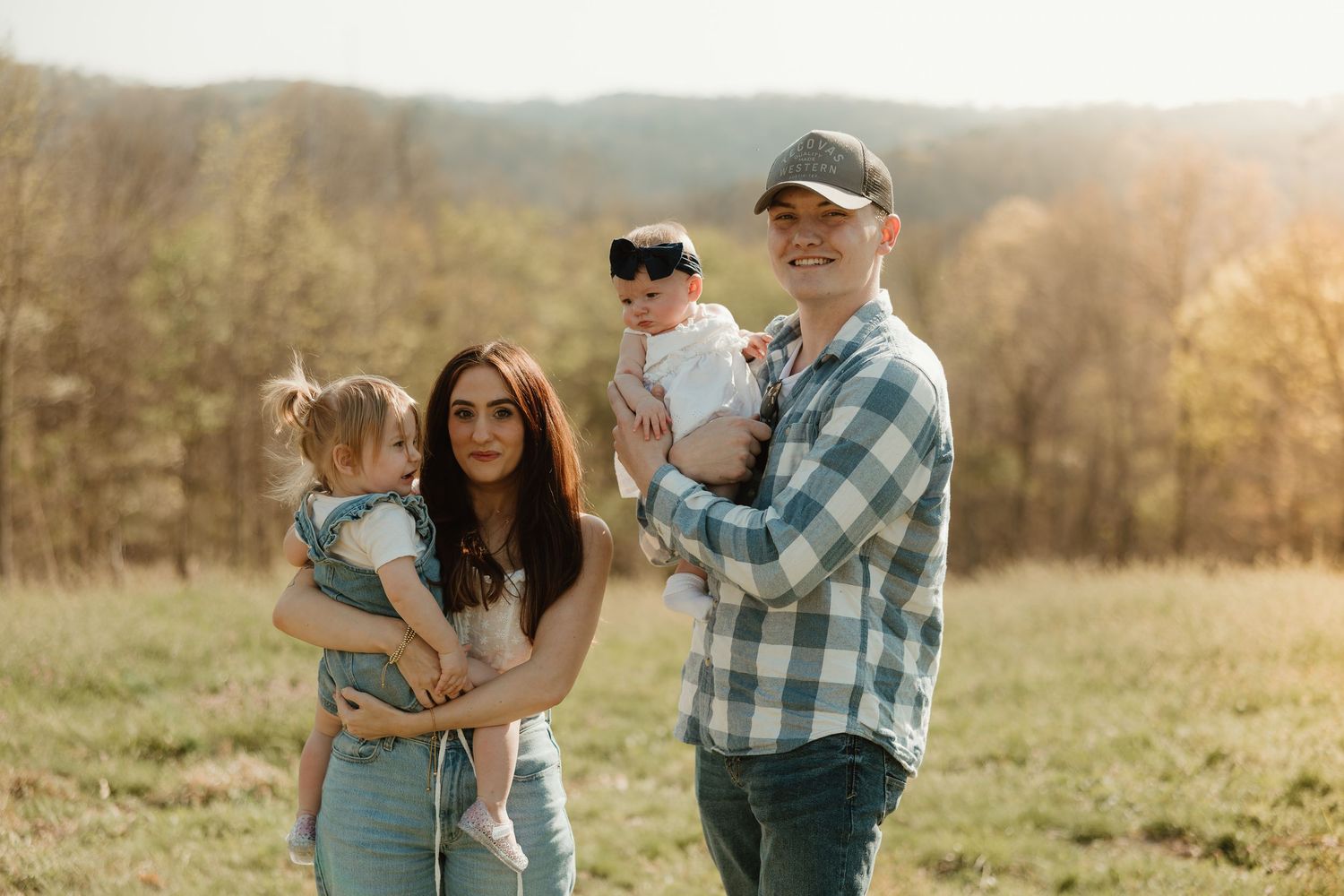 Family enjoying outdoor time together in a scenic autumn field with natural lighting and plaid shirt details.