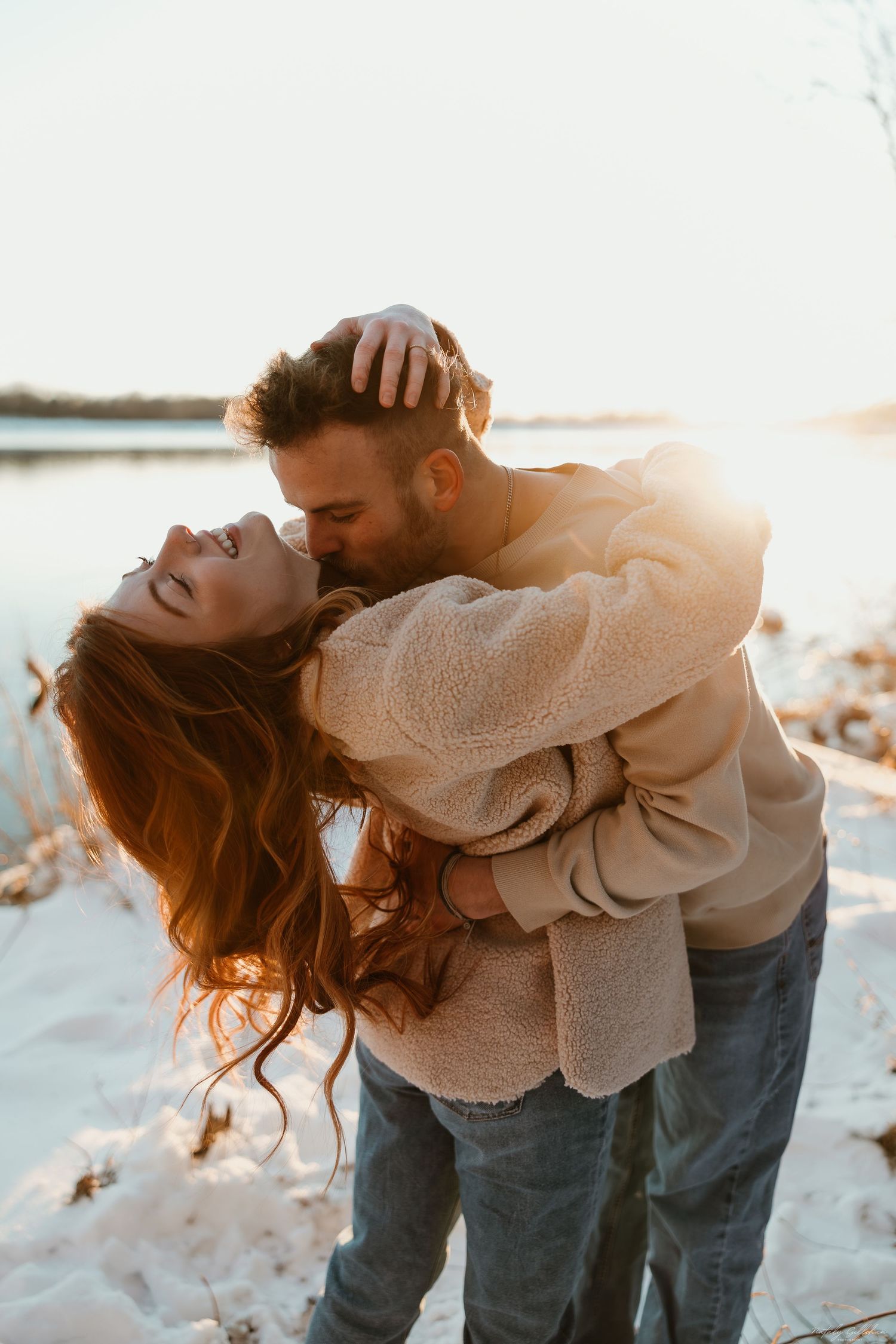 Romantic moment between a couple sharing an intimate embrace in snowy winter scenery.