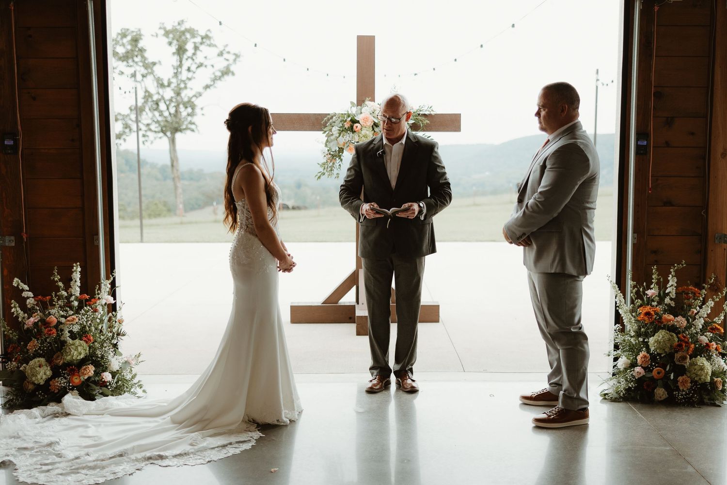 A series of romantic wedding moments captured in silhouette against large windows in a rustic venue.