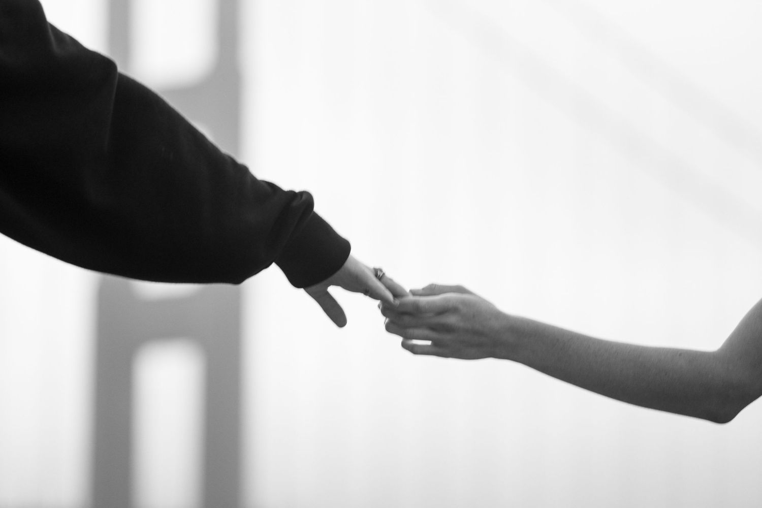 Hands exchanging a credit card or payment card in a professional transaction against a bright background.