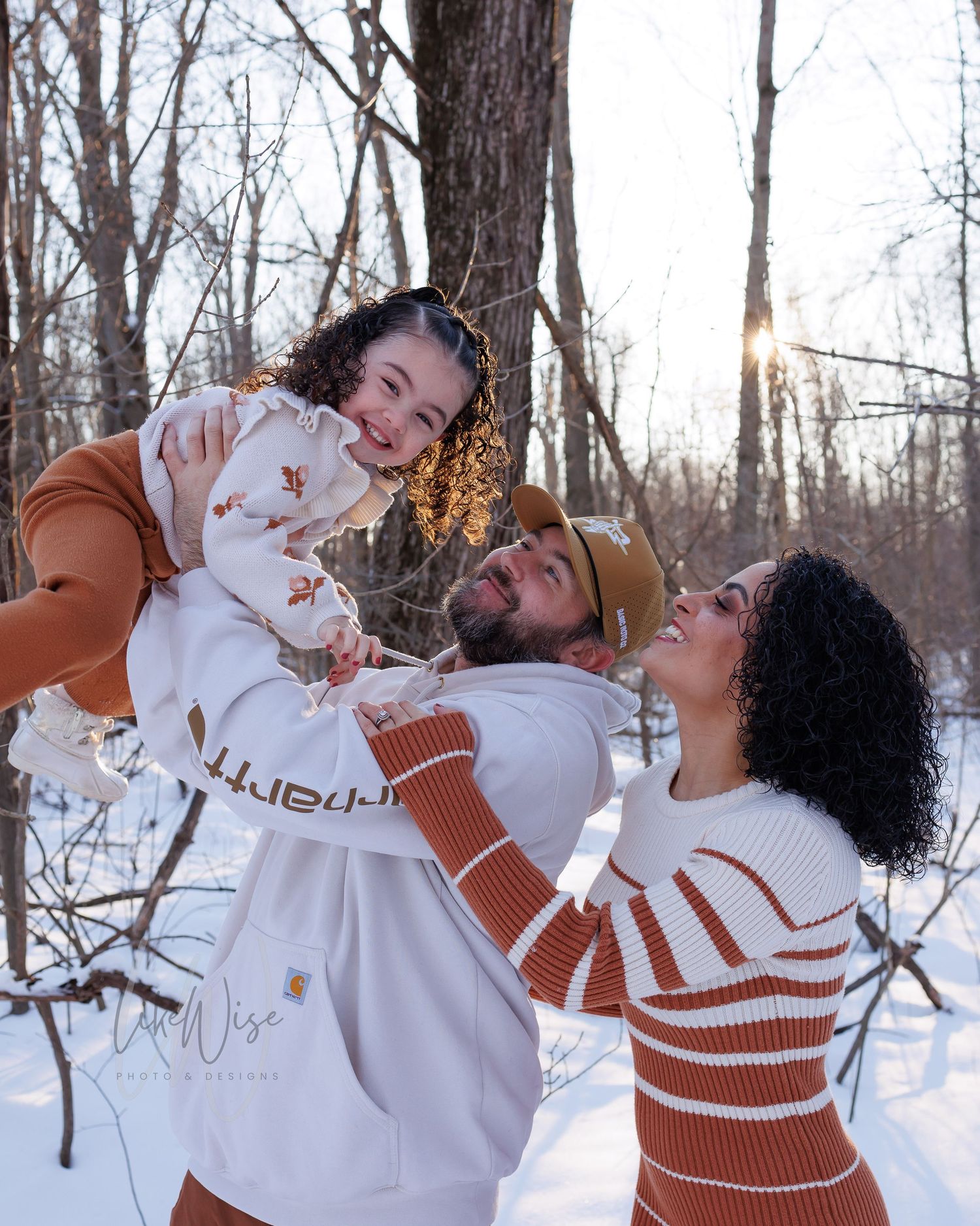 A group enjoying hot drinks together in a winter forest setting wearing matching brown and white sweaters.