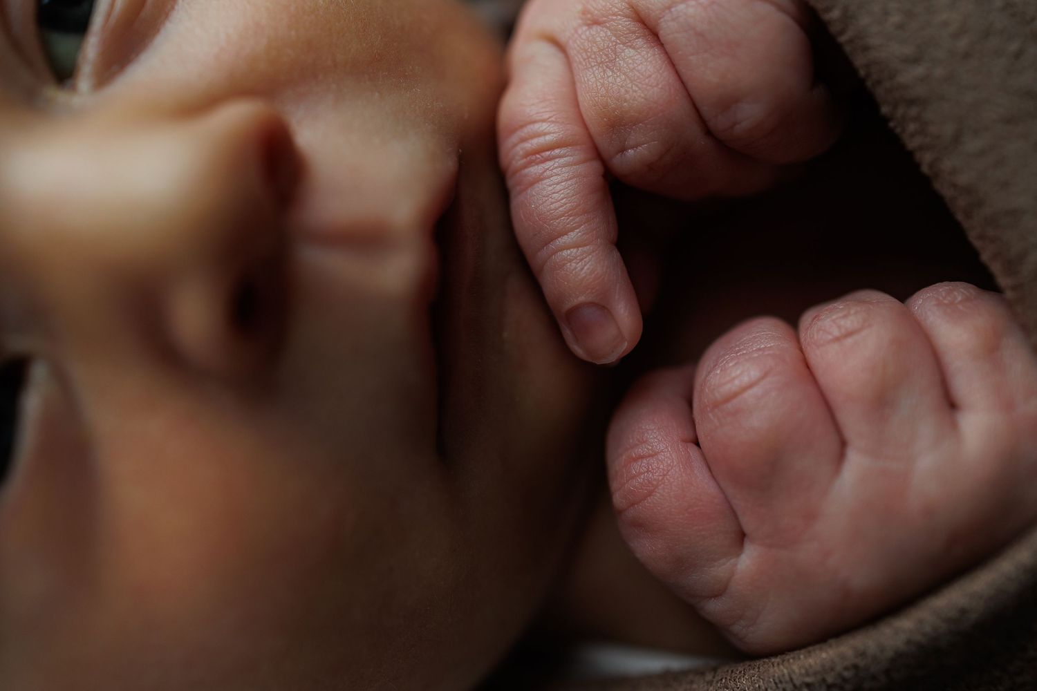 A row of tiny baby feet lined up in a horizontal arrangement showing different skin tones and positions.
