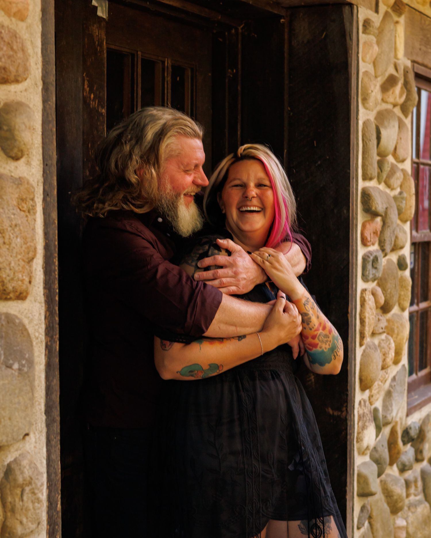 Couple sharing a joyful moment in stone doorway.