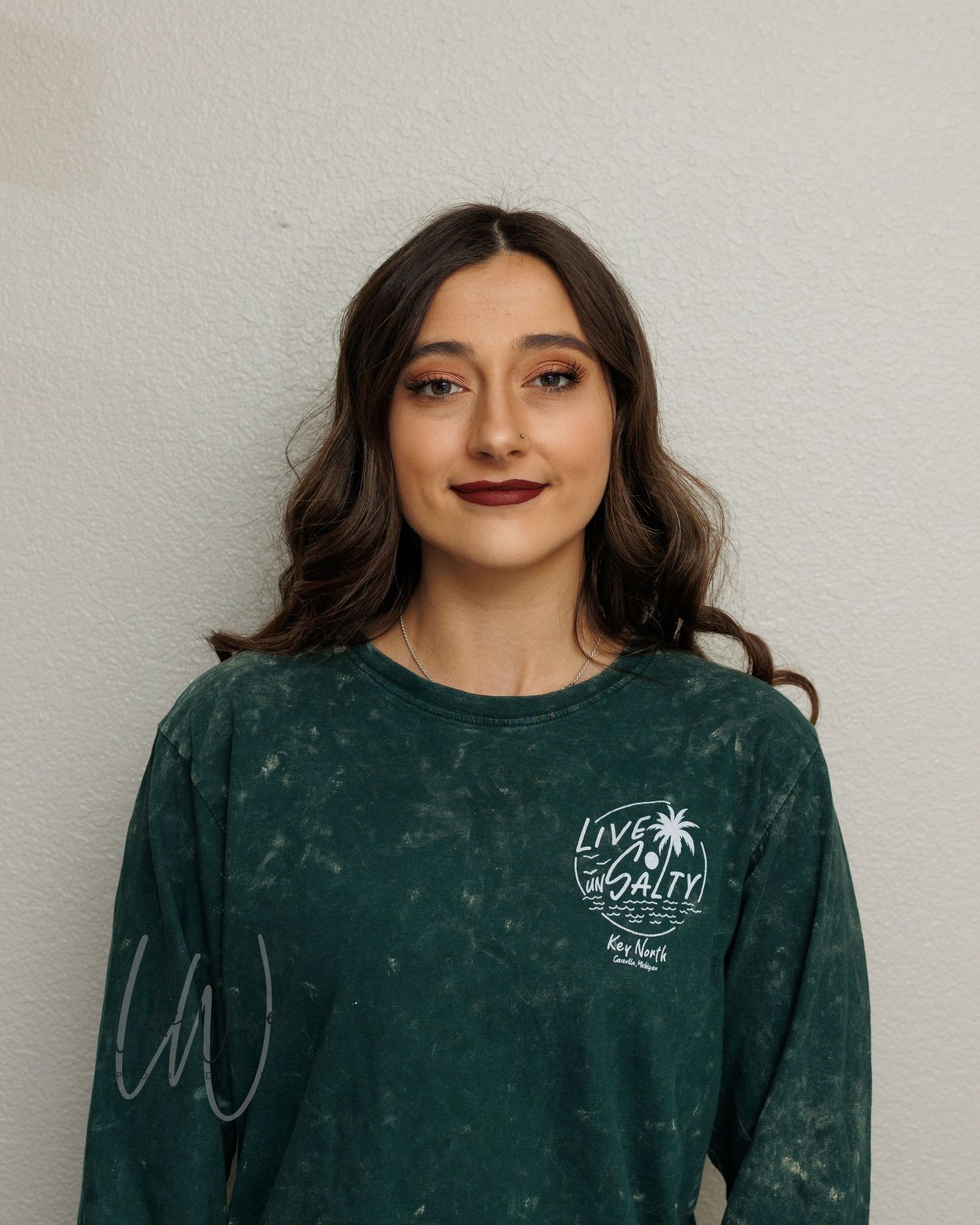 Dark green sweatshirt with white palm tree logo being displayed against white wall in multiple angles.