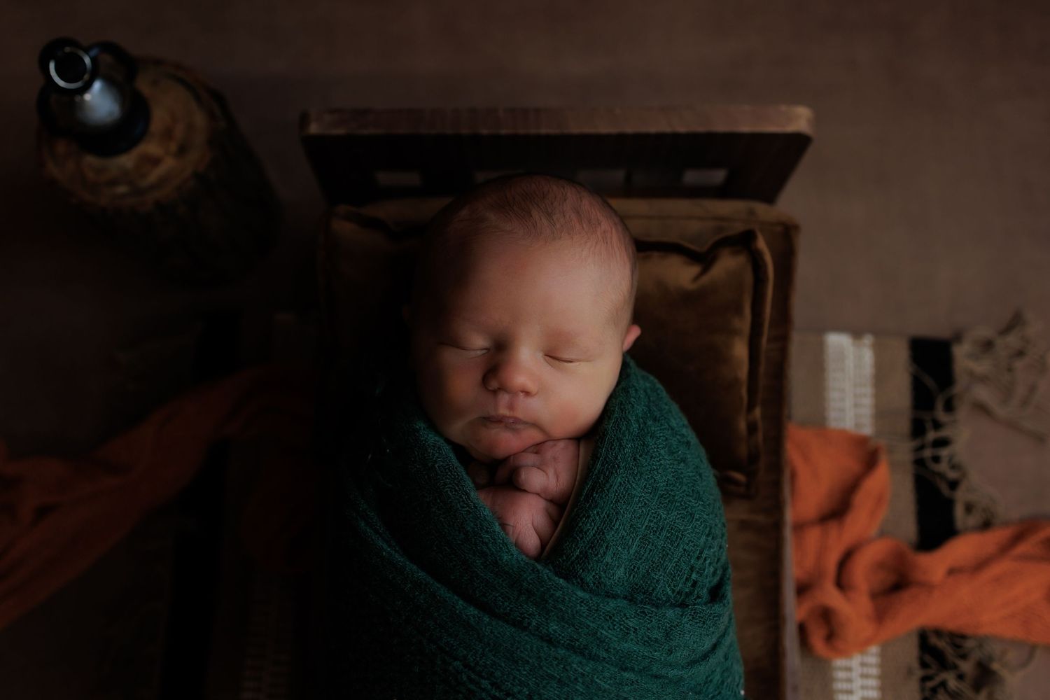 A collection of newborn photography portraits showing a sleeping baby in various poses with green and brown tones.