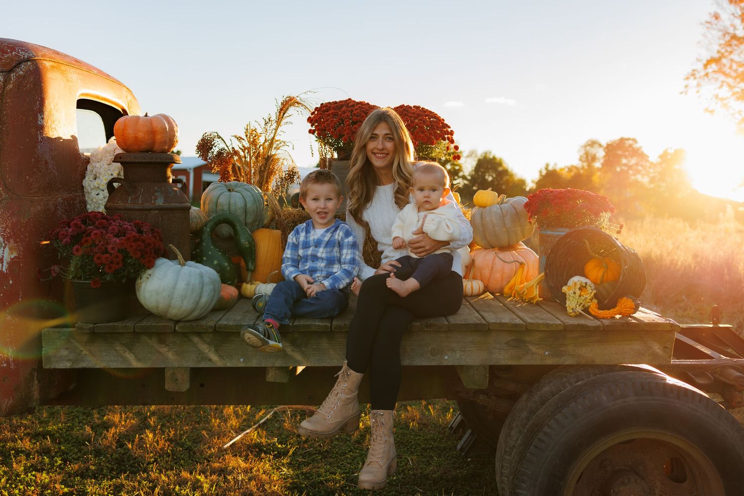 A group of people enjoying a sunset hayride on a farm wagon during autumn harvest season.