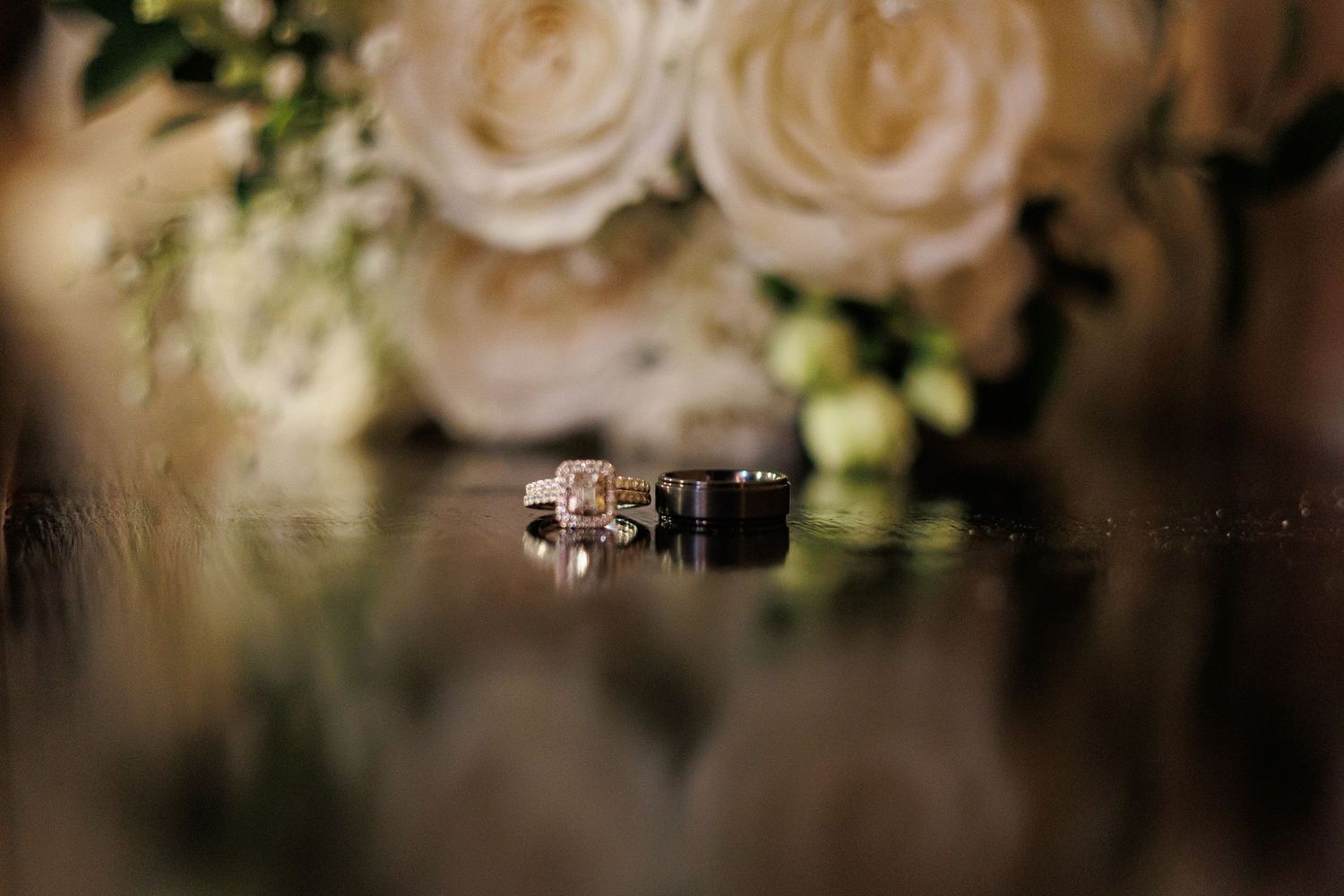 Elegant white roses and floral arrangements decorate a romantic wedding reception table setting.