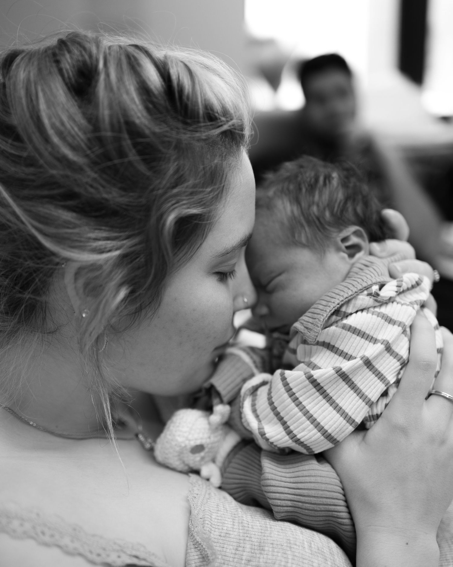 Black and white photo series showing tender moments of gentle hugs and nuzzles between parent and child.