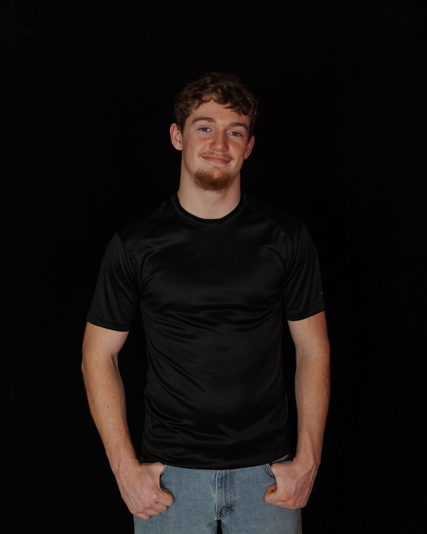 A sequence of four photos showing a person in a black t-shirt and jeans against a dark background.
