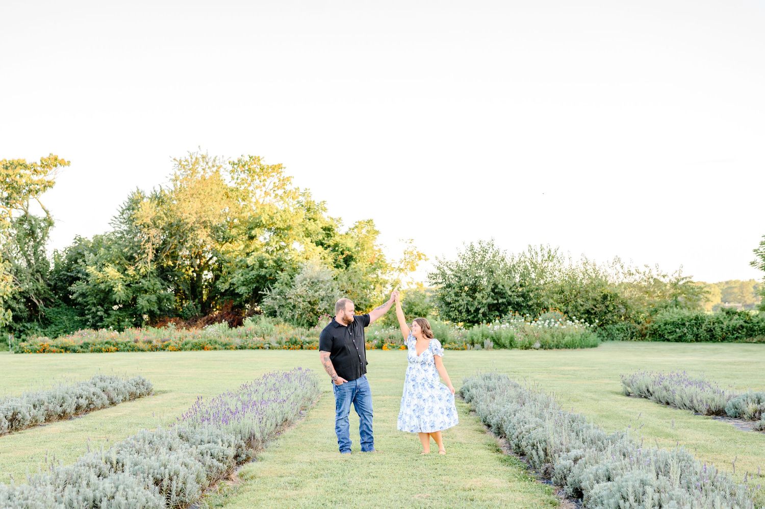 Family walking through a beautiful lavender field at sunset with purple flowers stretching into the distance.