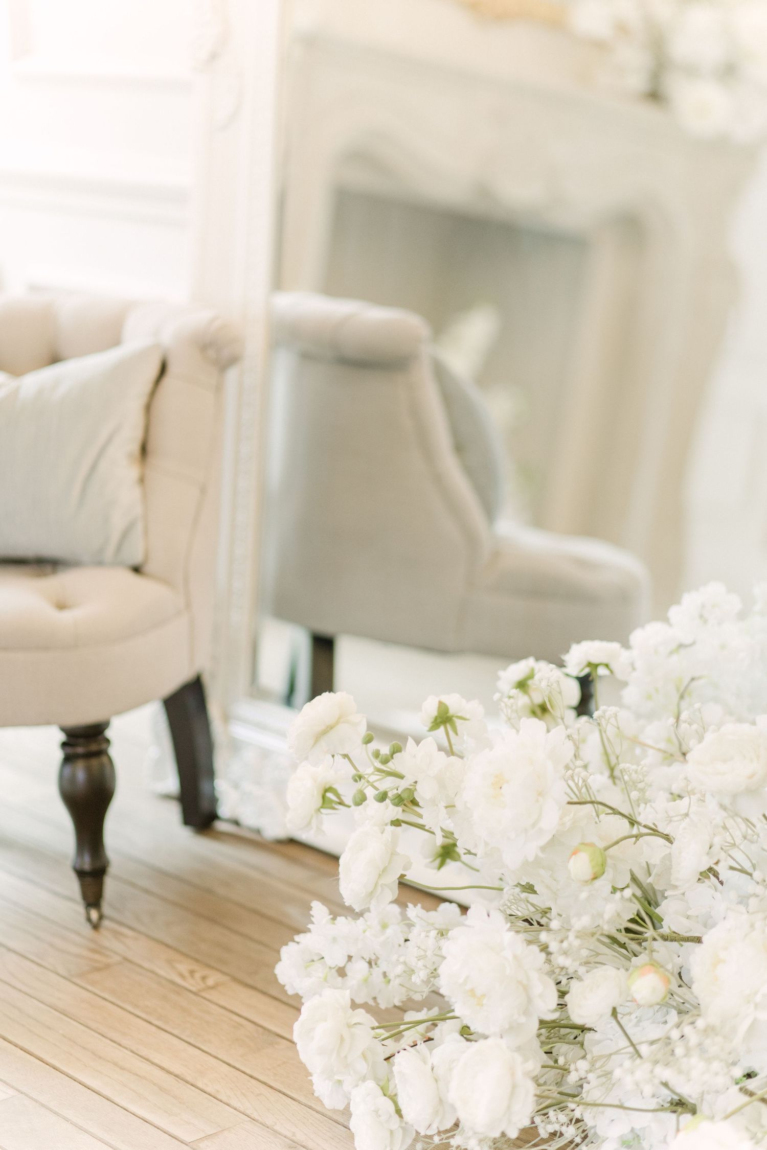 White floral arrangements with delicate blooms displayed on a wooden table in a bright, airy setting.