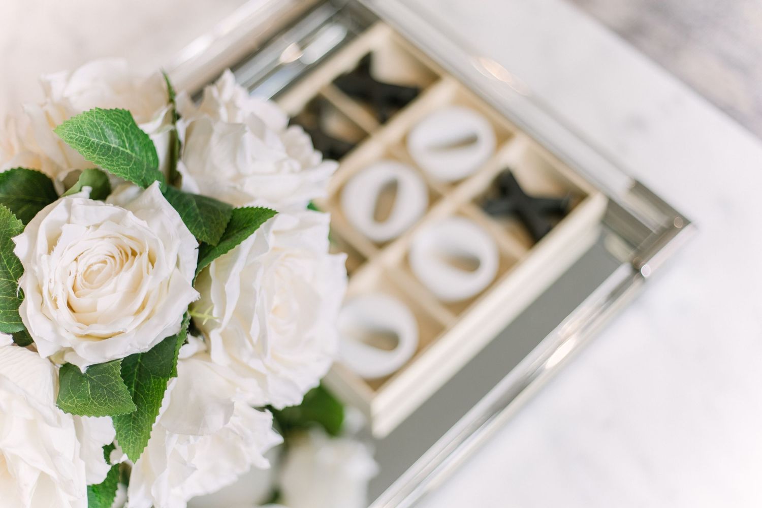 White roses and delicate floral arrangements create an elegant wedding reception table setting with soft romantic lighting.