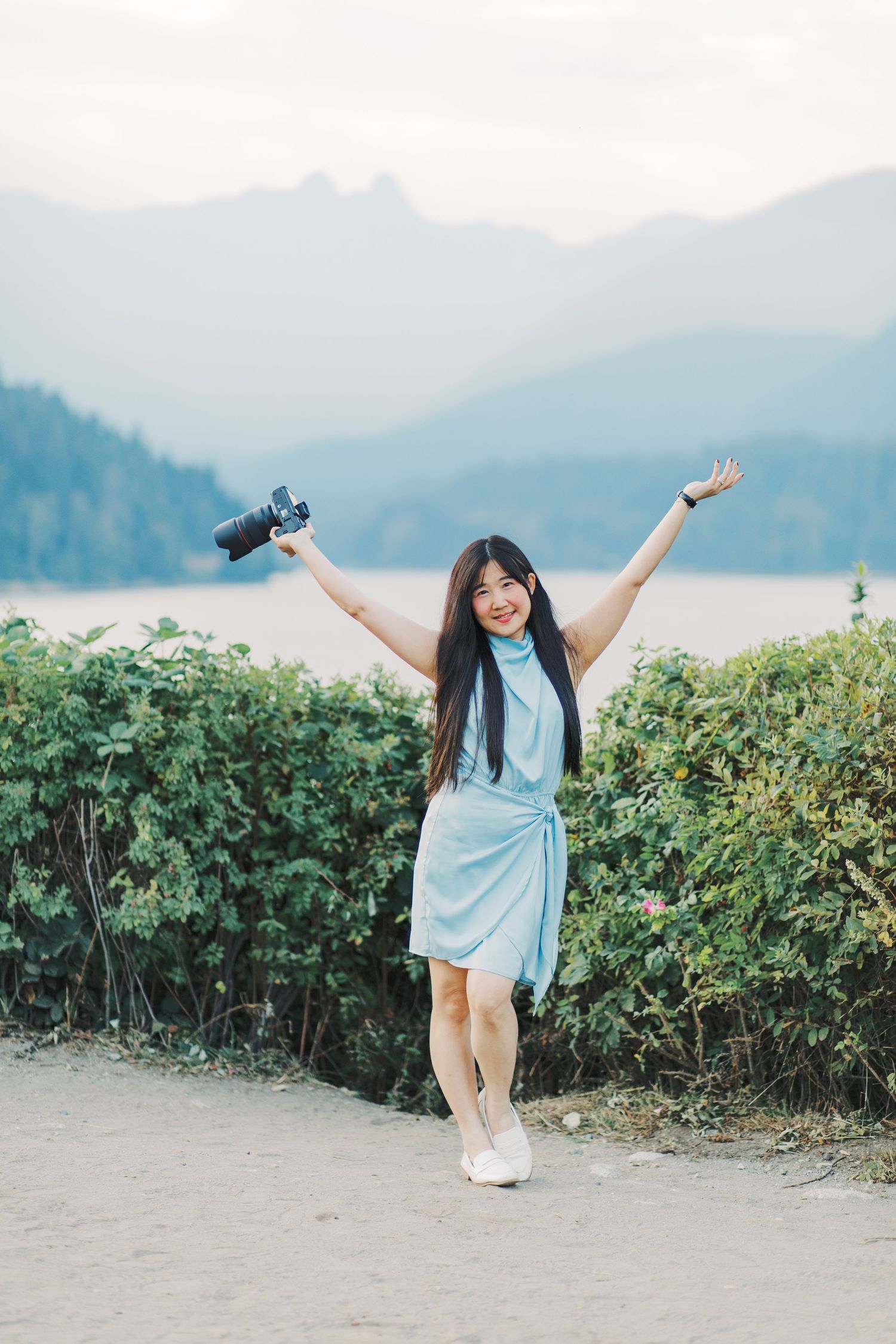 A series of candid shots shows a person in a light blue dress enjoying a scenic mountain landscape with greenery.