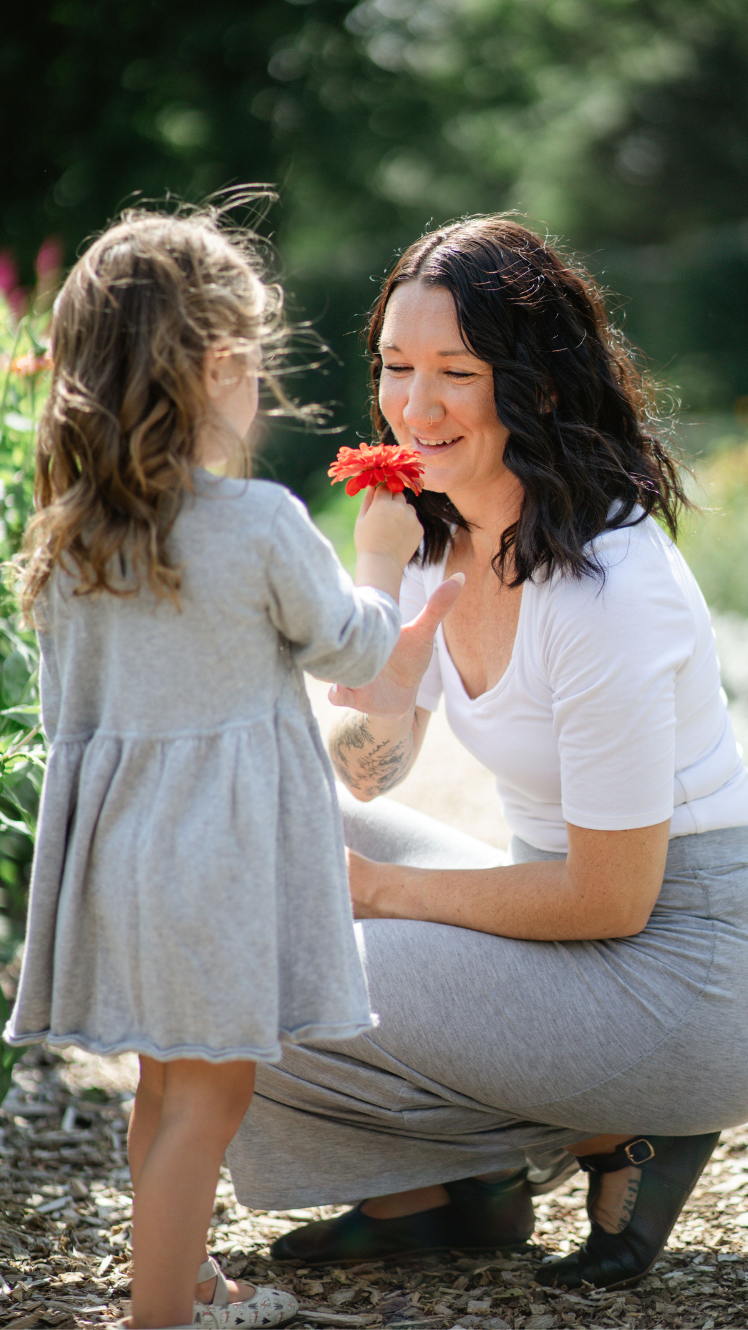 A sweet moment shared in a flower garden with a red bloom.