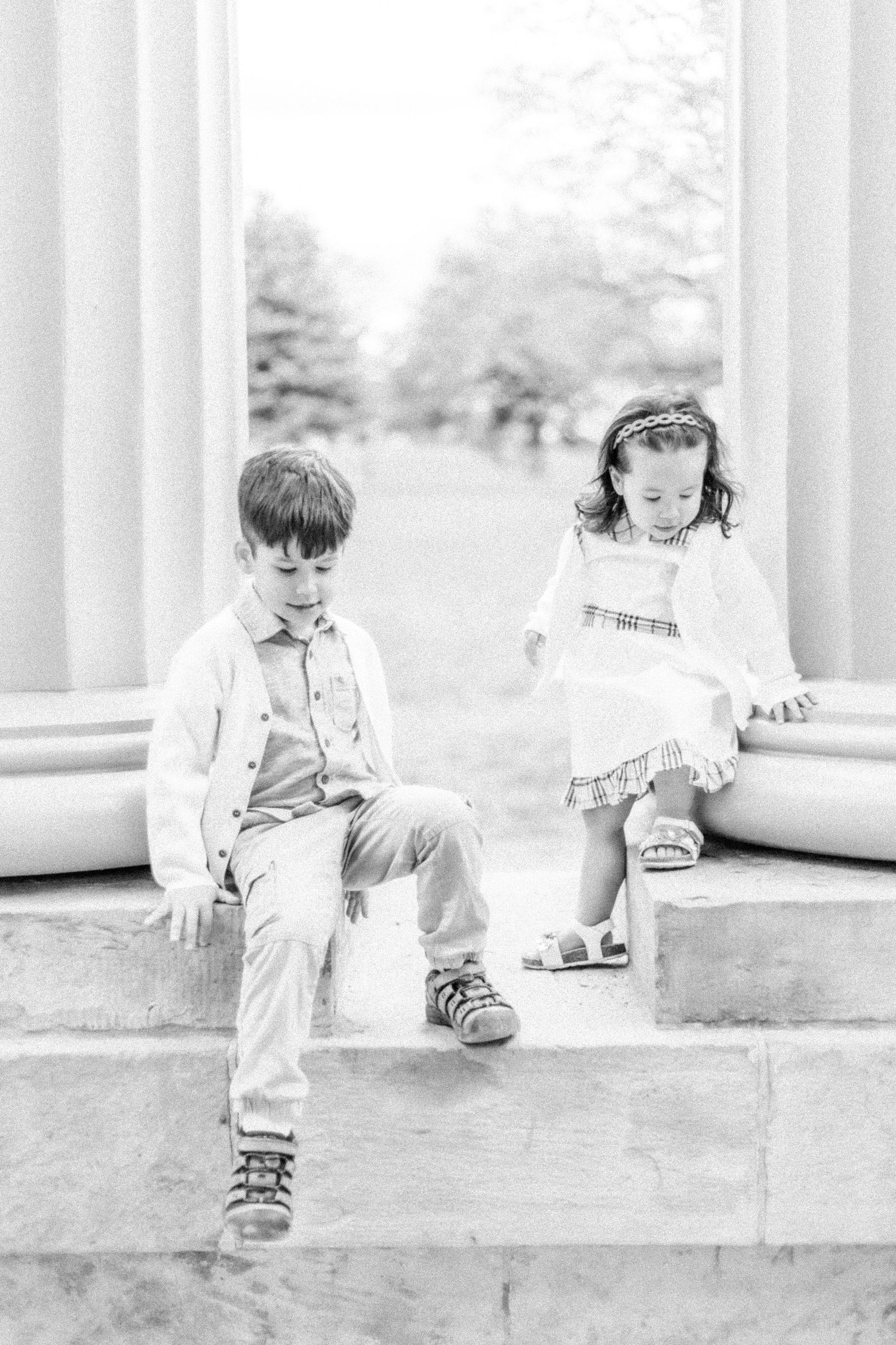 A black and white photo series shows a small child playing with toys on a porch in vintage-style overalls and shoes.