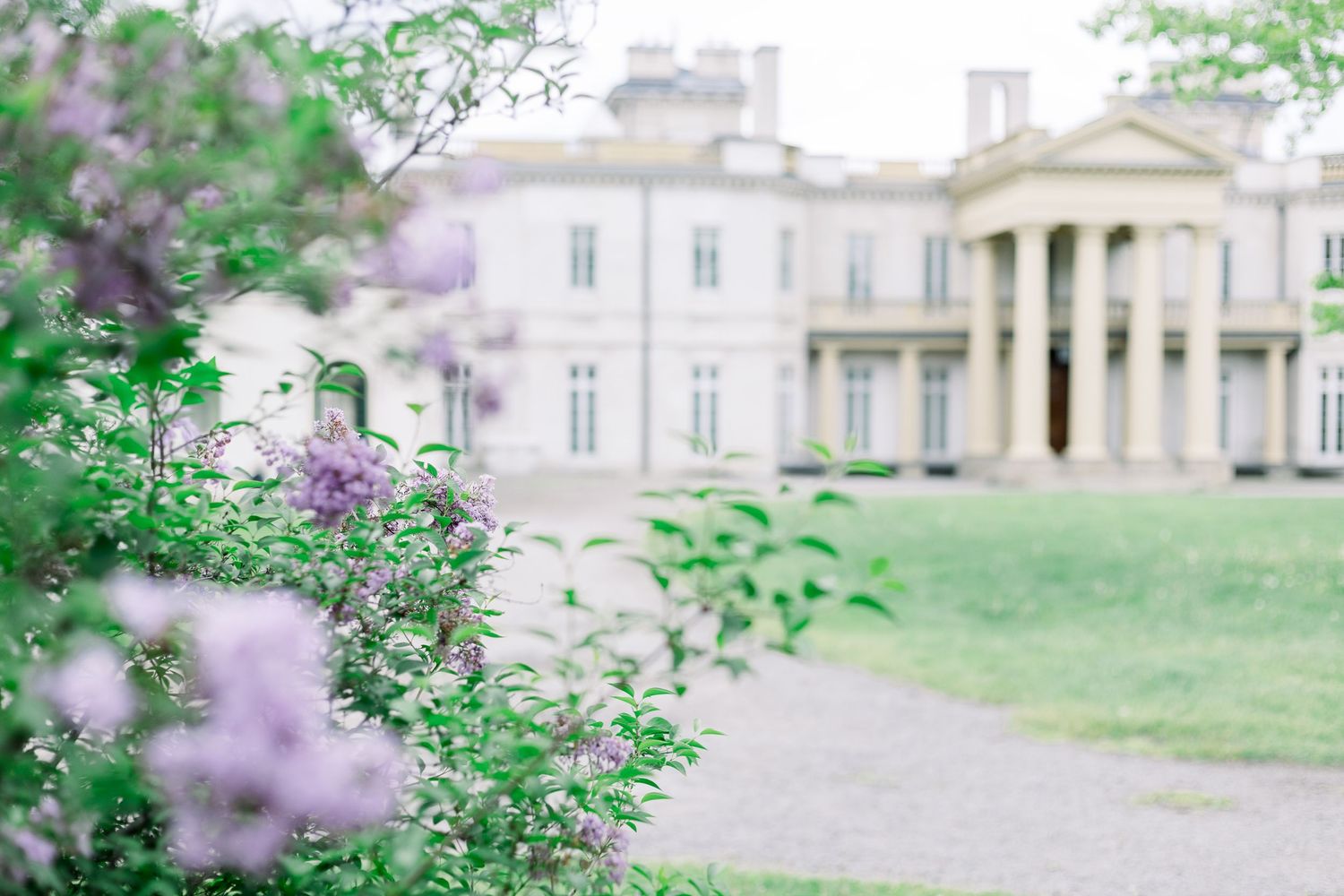 Elegant French chateau with manicured gardens and blooming spring flowers creates a romantic countryside setting.