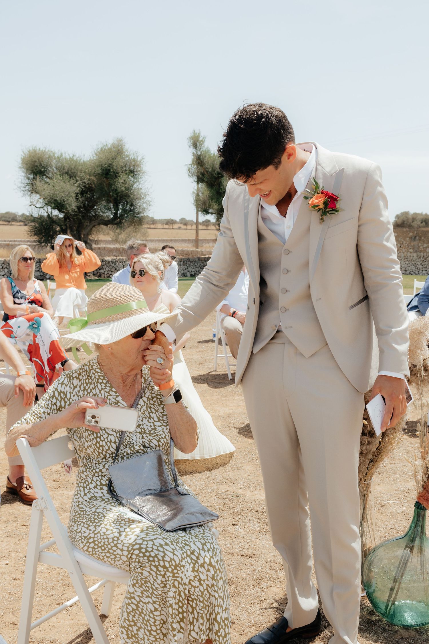 A charming moment between wedding guests during an outdoor desert celebration.