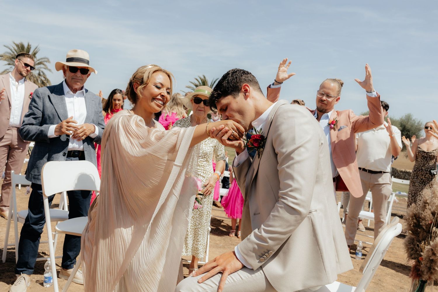 Celebratory dance moment at an outdoor wedding with guests watching.