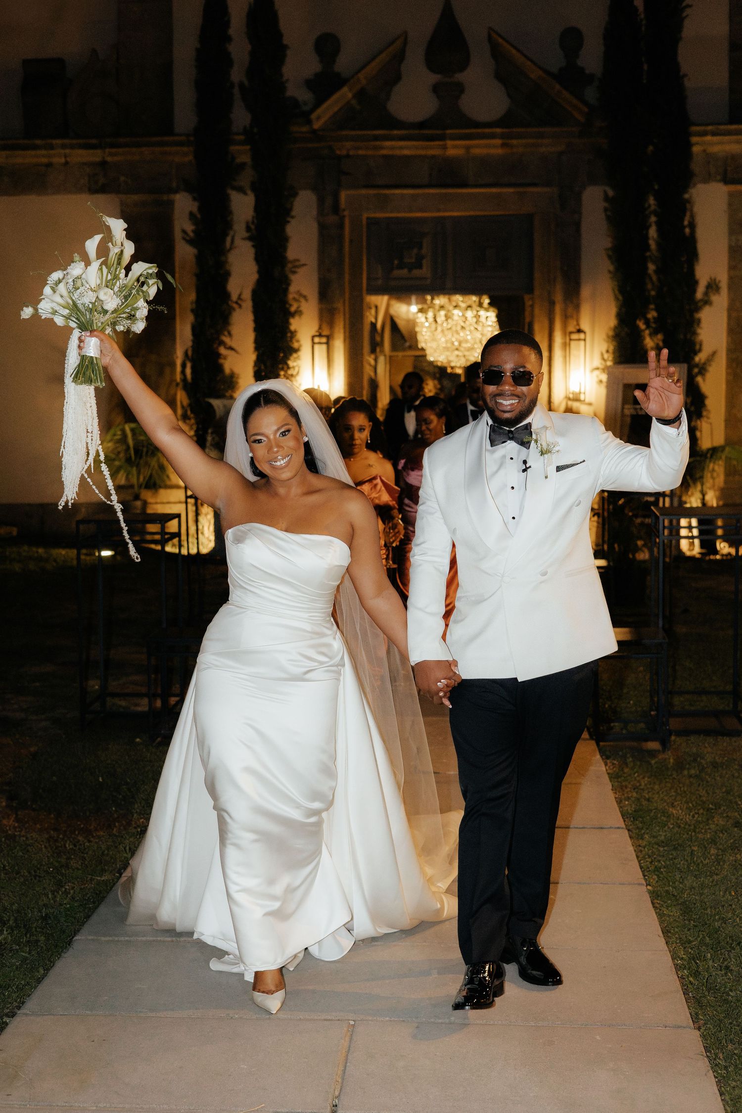 Joyful bride and groom exit in style. Outdoor wedding in Portugal with classic, elegant attire.
