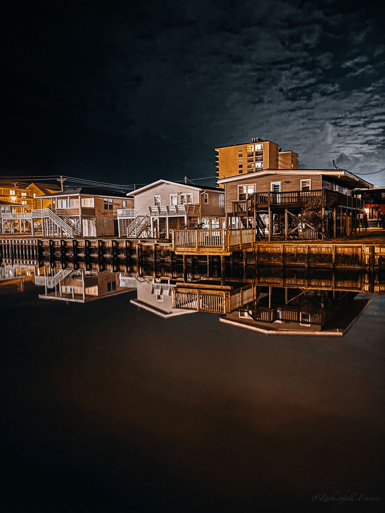 Waterfront buildings reflecting on the water at night in Myrtle Beach.