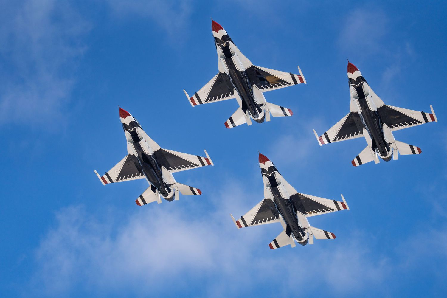 Four U.S. Air Force Thunderbirds flying in formation during an airshow.