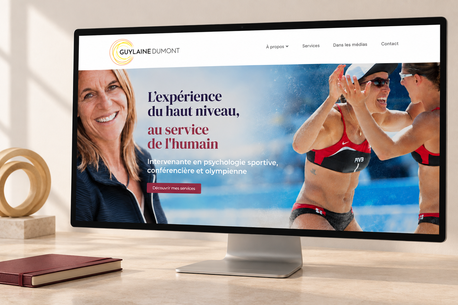 A computer monitor displaying a French sports coaching website with a smiling woman and beach volleyball players.