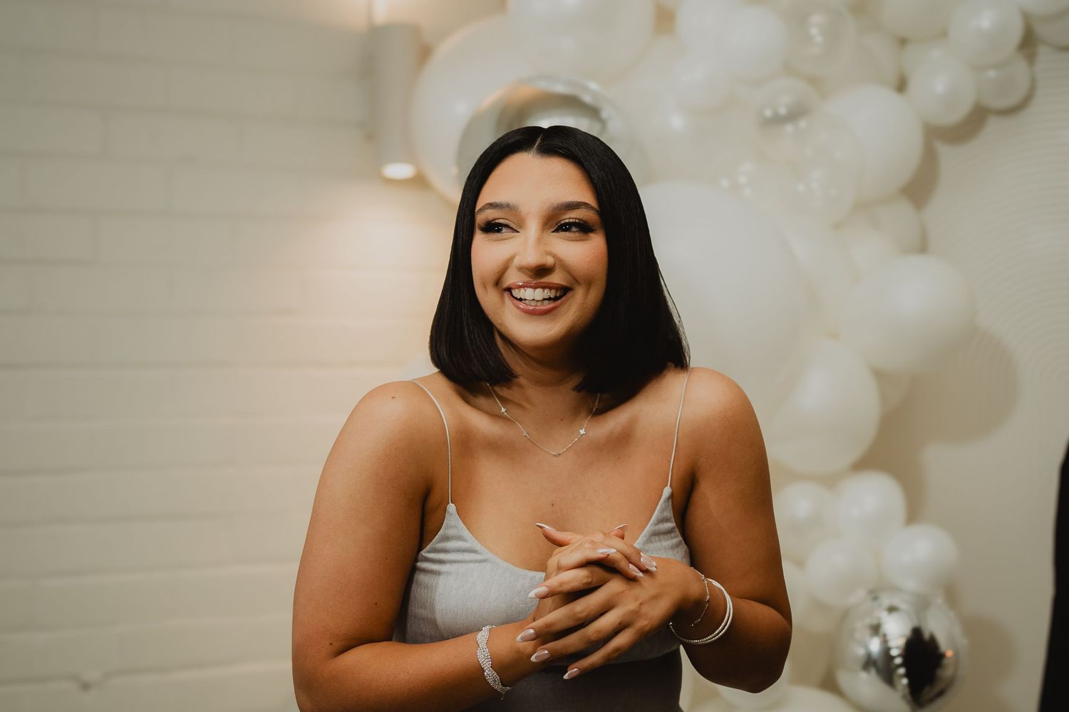 Birthday portrait in front of a white balloon arch