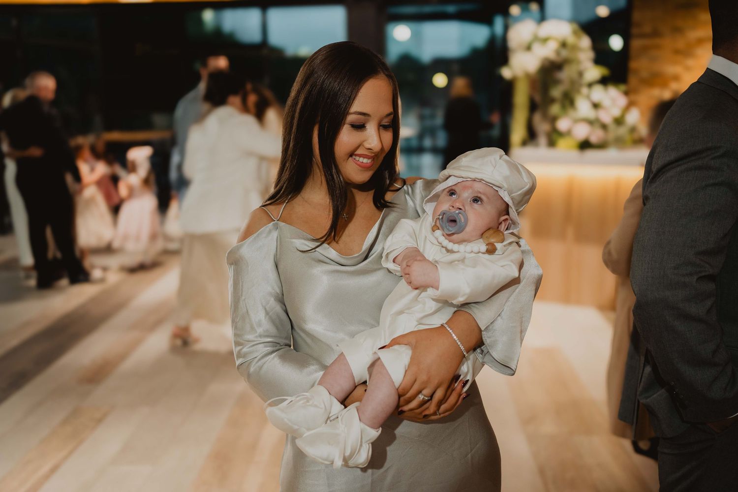Guest holding a baby at a christening reception in Melbourne