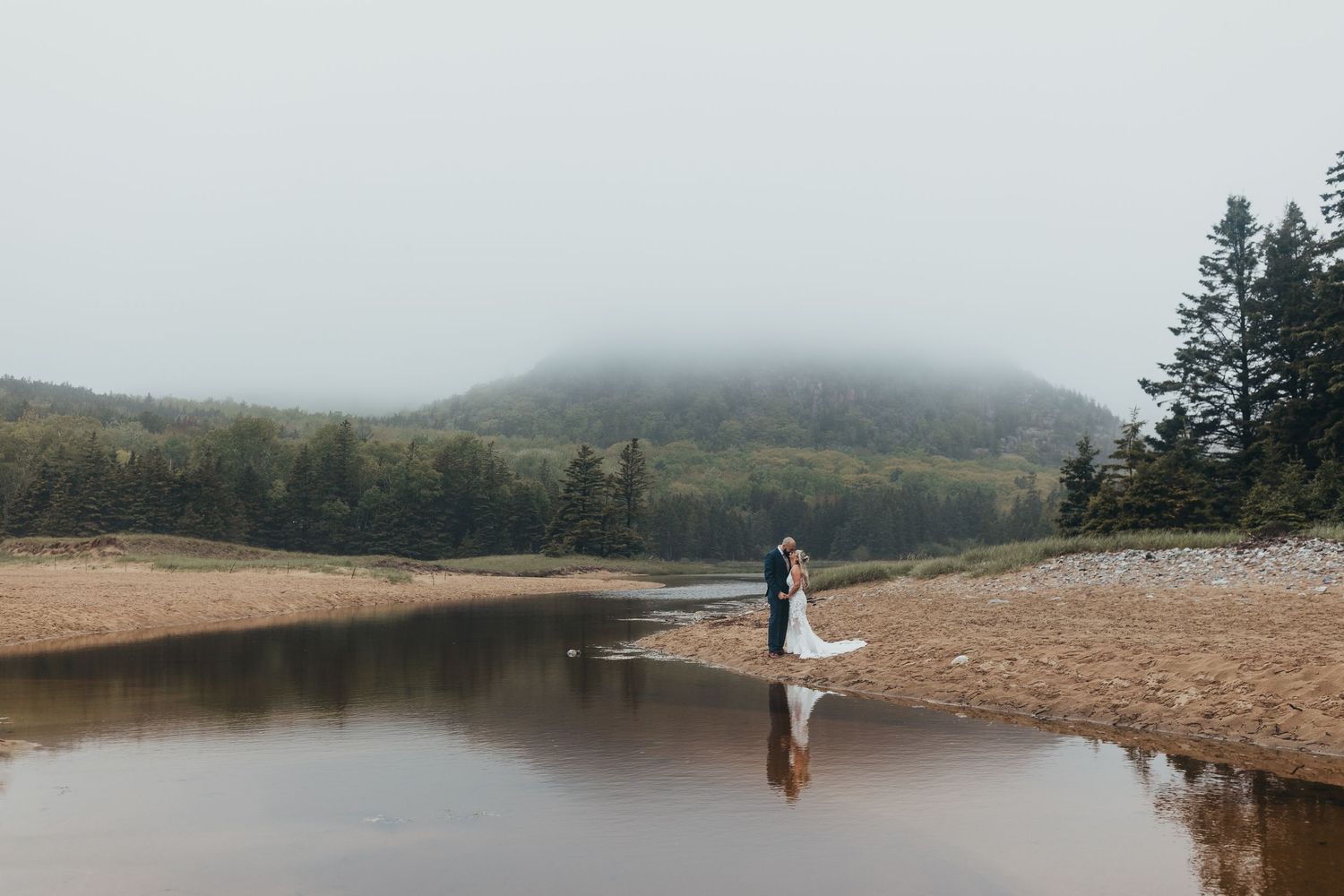 Foggy beach landscape with mountains and pine trees along the rocky coastline. Elopement Acadia National Park, Bar Harbor Maine