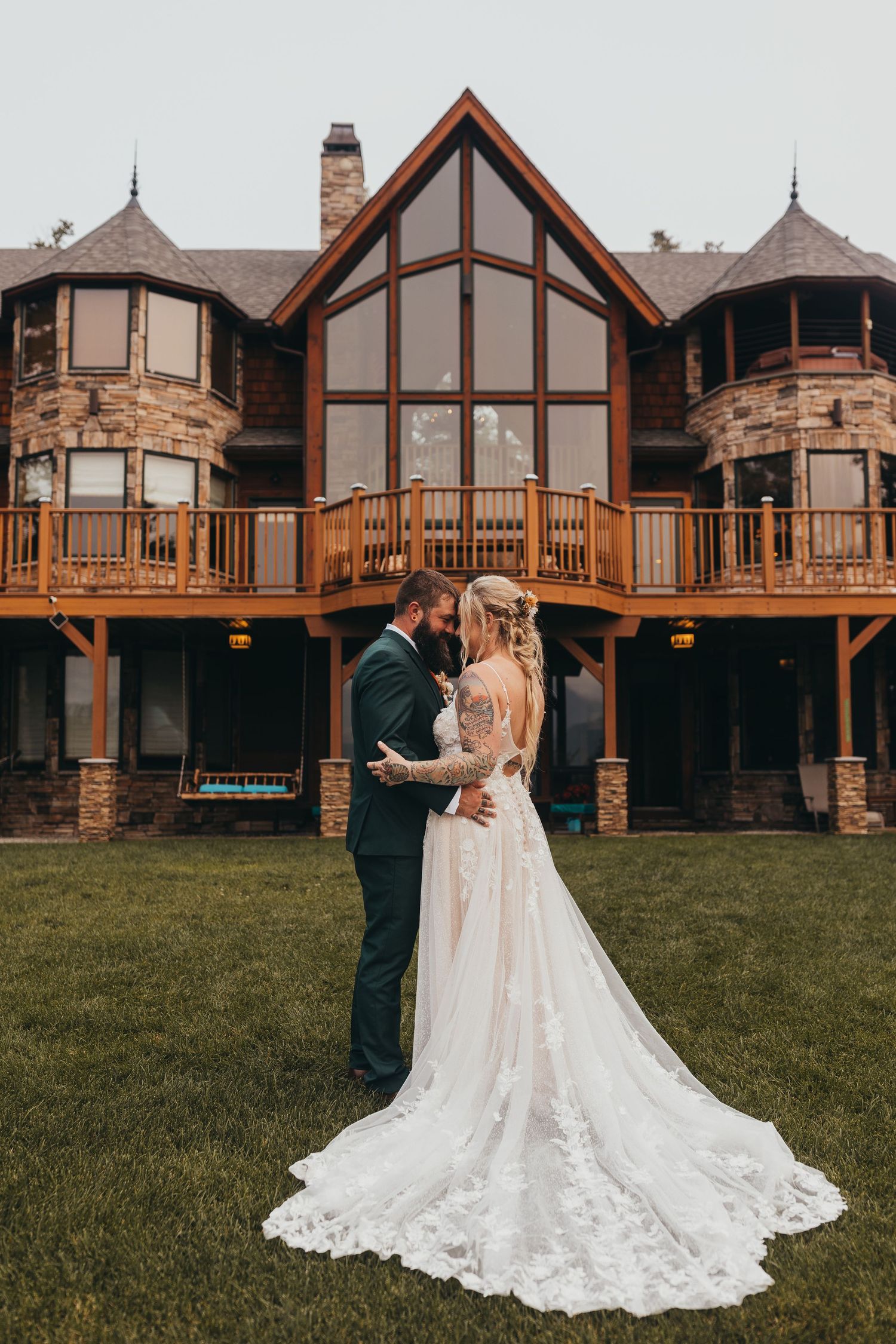 Elegant wedding photos taken outside a grand mountain lodge with stone and wood architecture.