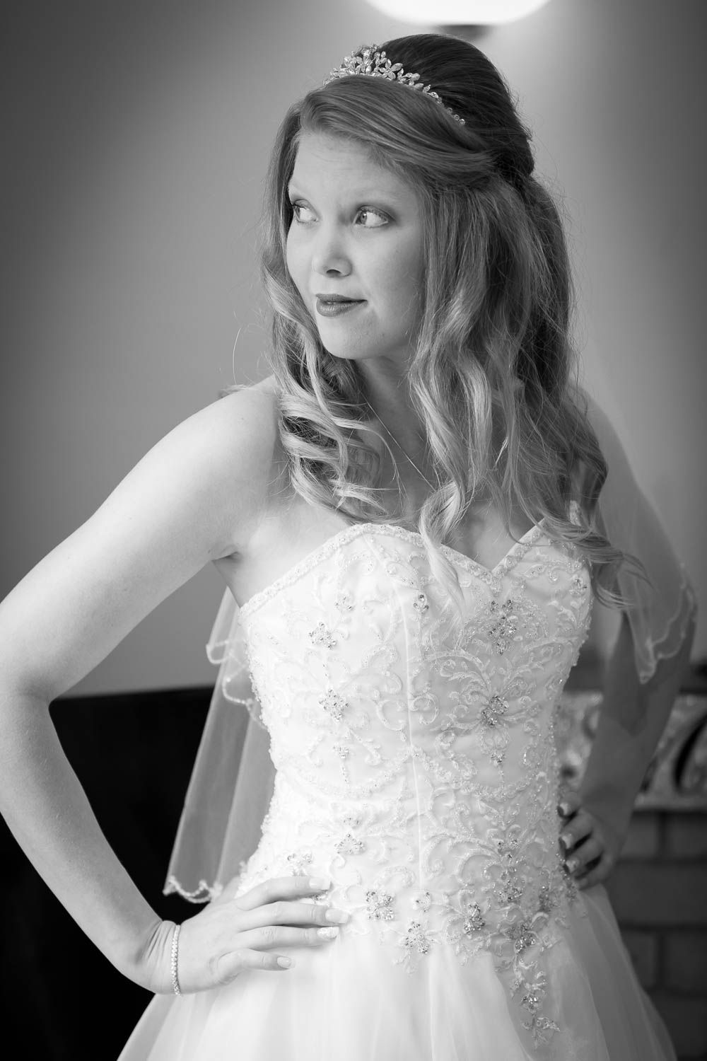 Black and white wedding photo showing a bride in a strapless lace gown with flowing veil and delicate tiara.