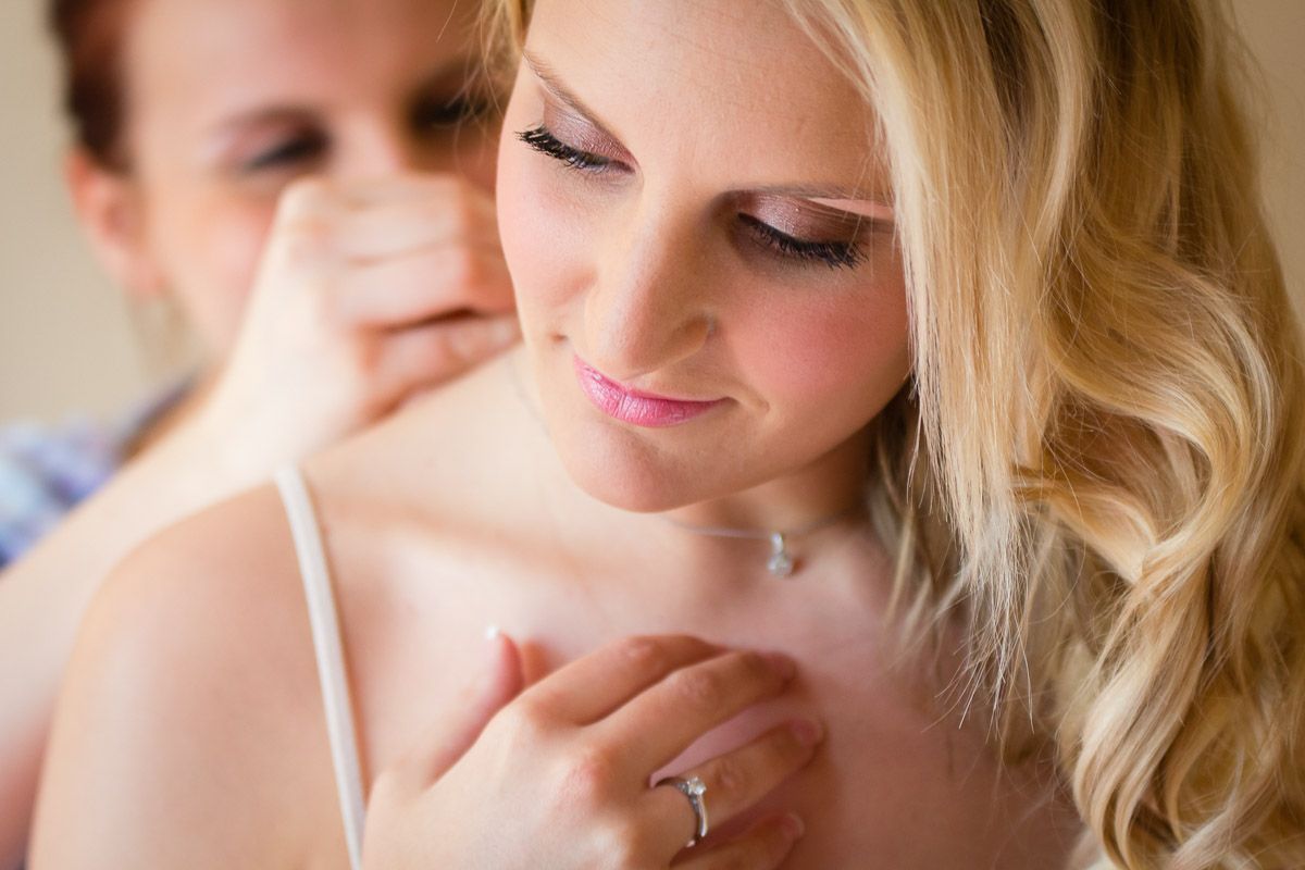 A tender romantic moment between a couple with the focus on a diamond engagement ring.