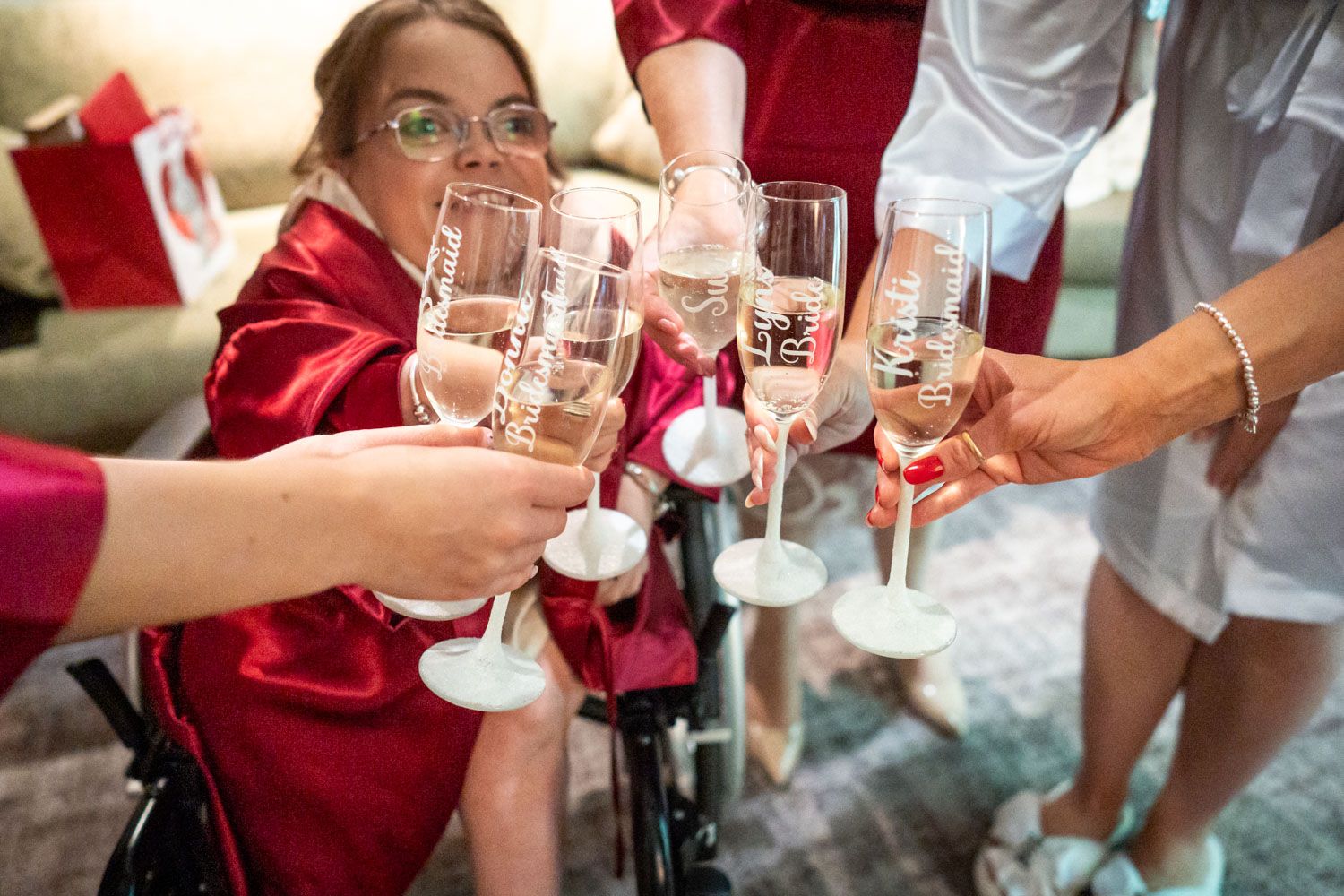 Guests raise champagne glasses in a celebratory toast during a wedding reception.