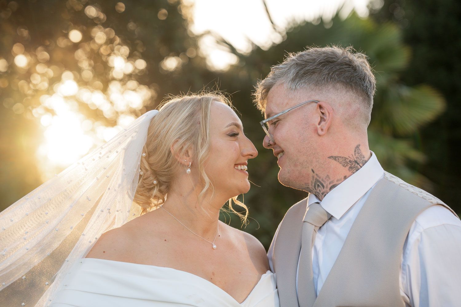 Romantic golden hour wedding photos show couple sharing intimate moments in a sun-drenched outdoor setting.