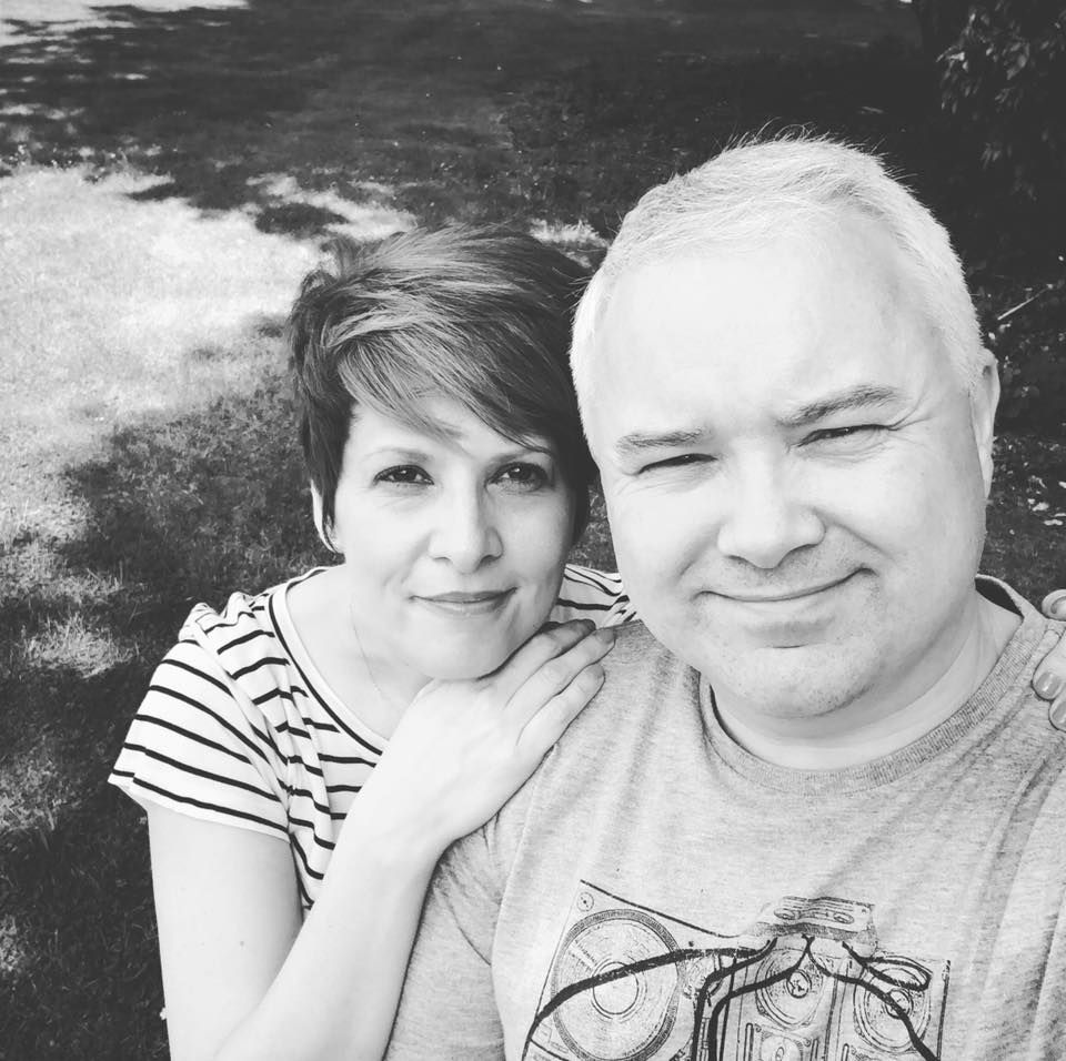 Black and white portrait of a smiling couple relaxing together outdoors in natural light.