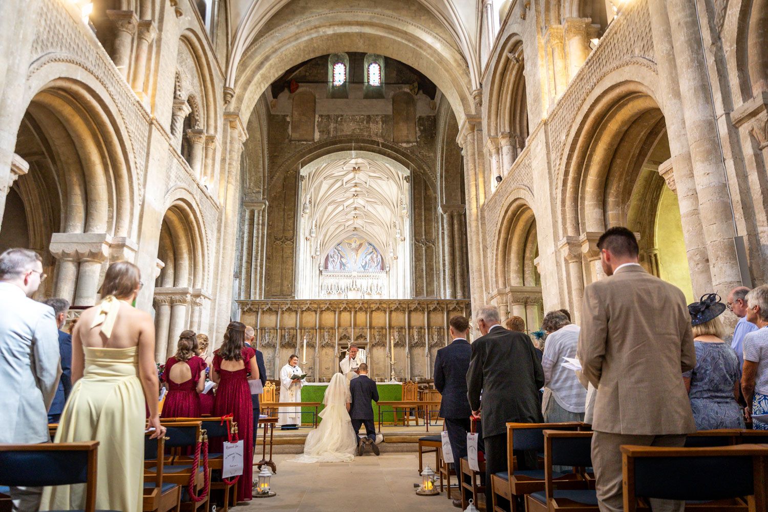Wedding ceremony inside a stunning historic cathedral with guests seated along the grand nave.