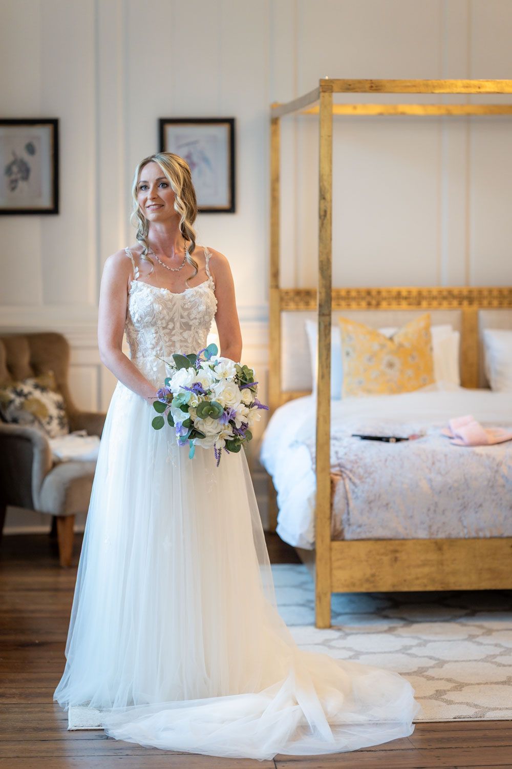 A bridal portrait session in an elegant bedroom with a canopy bed and white flowing wedding gown.