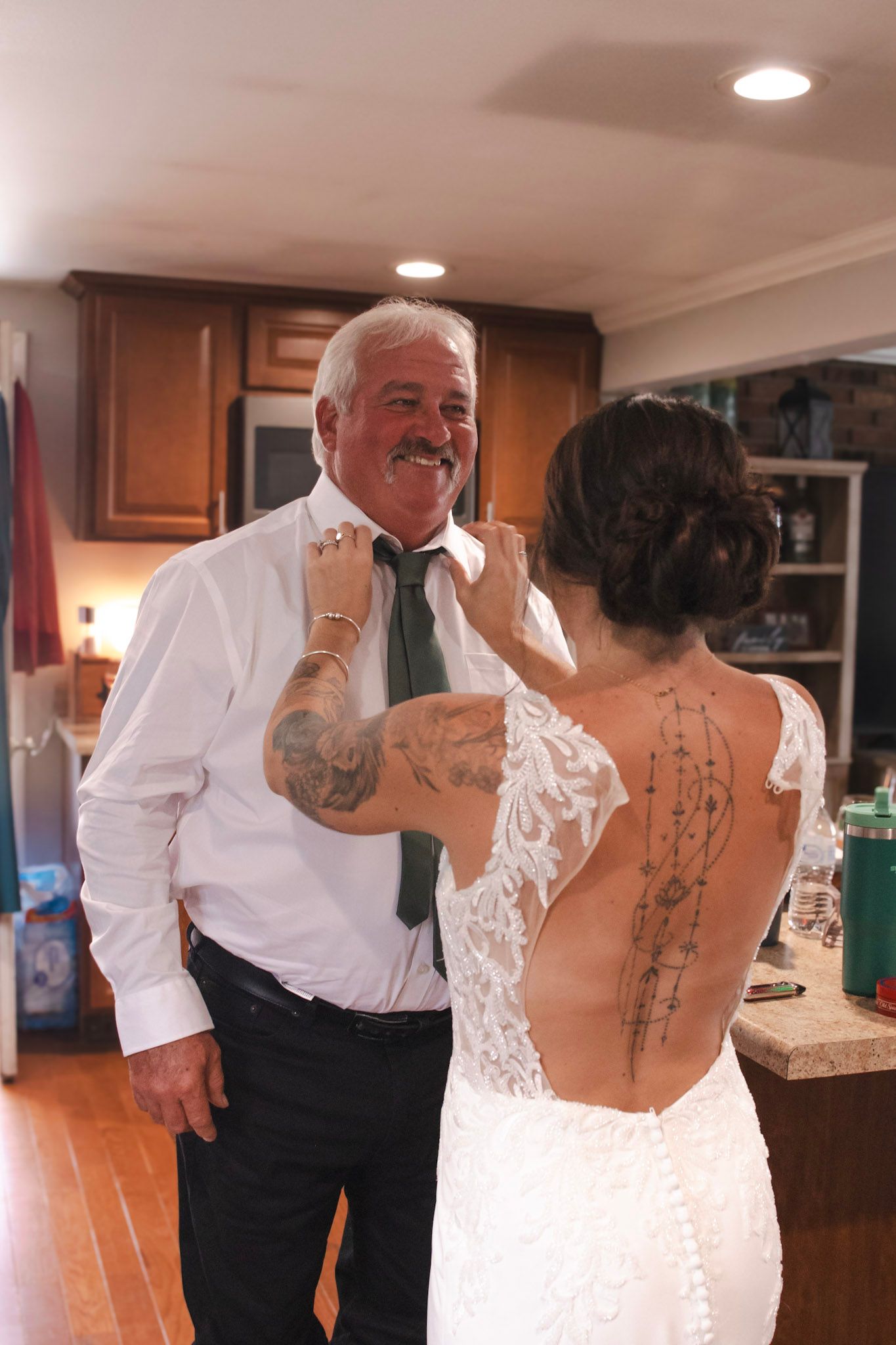 A close-up view of a white lace wedding dress back detail in an indoor setting.