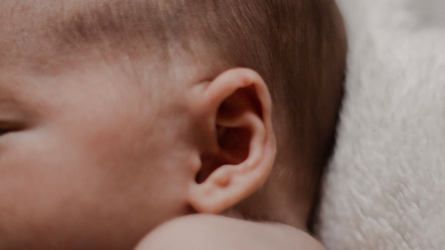Close up black and white portrait of a sleeping infant with soft focus.